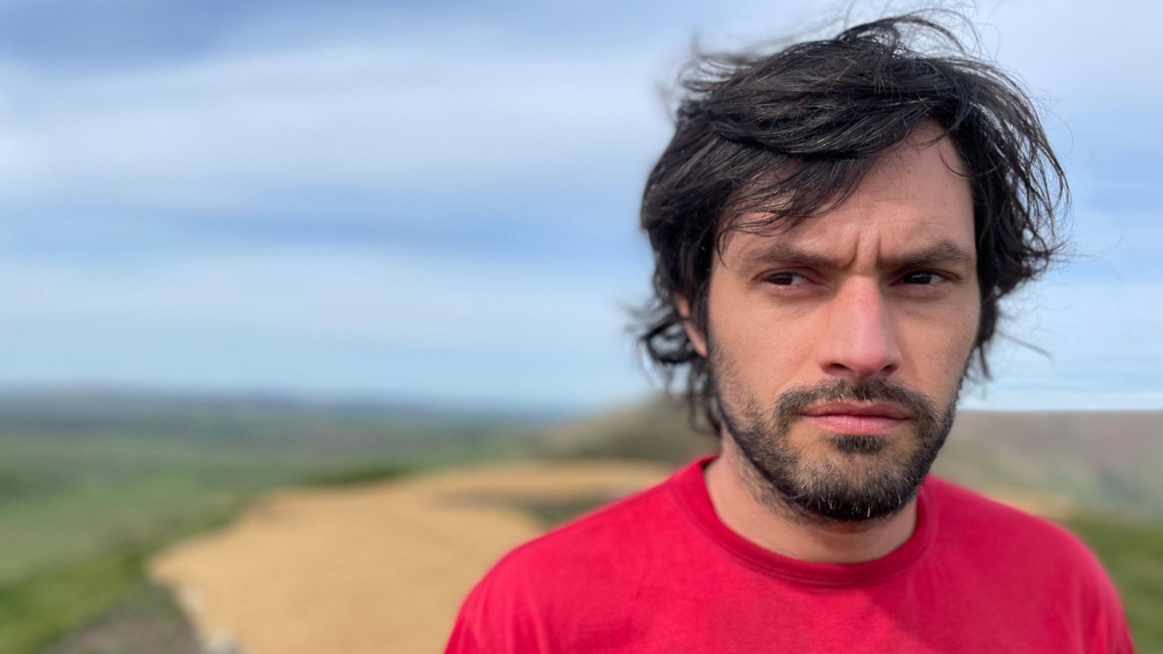 Park ranger with long dark hair and a red T-shirt in the open air