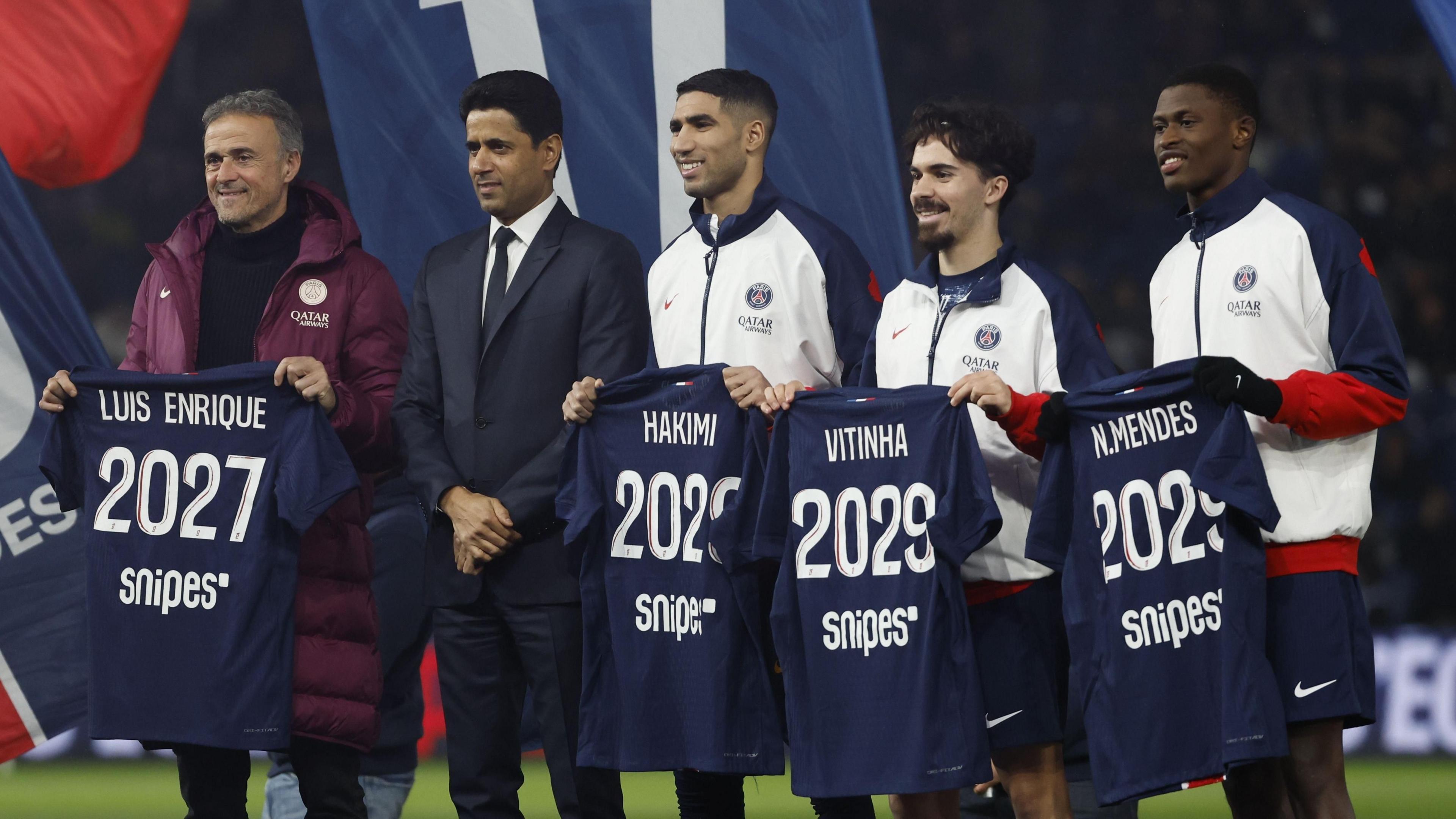 Head coach Luis Enrique, Paris Saint Germain's President Nasser Al Khelaifi, Achraf Hakimi, Vitinha, and Nuno Mendes pose for a photograph during the announcement of their contract extension