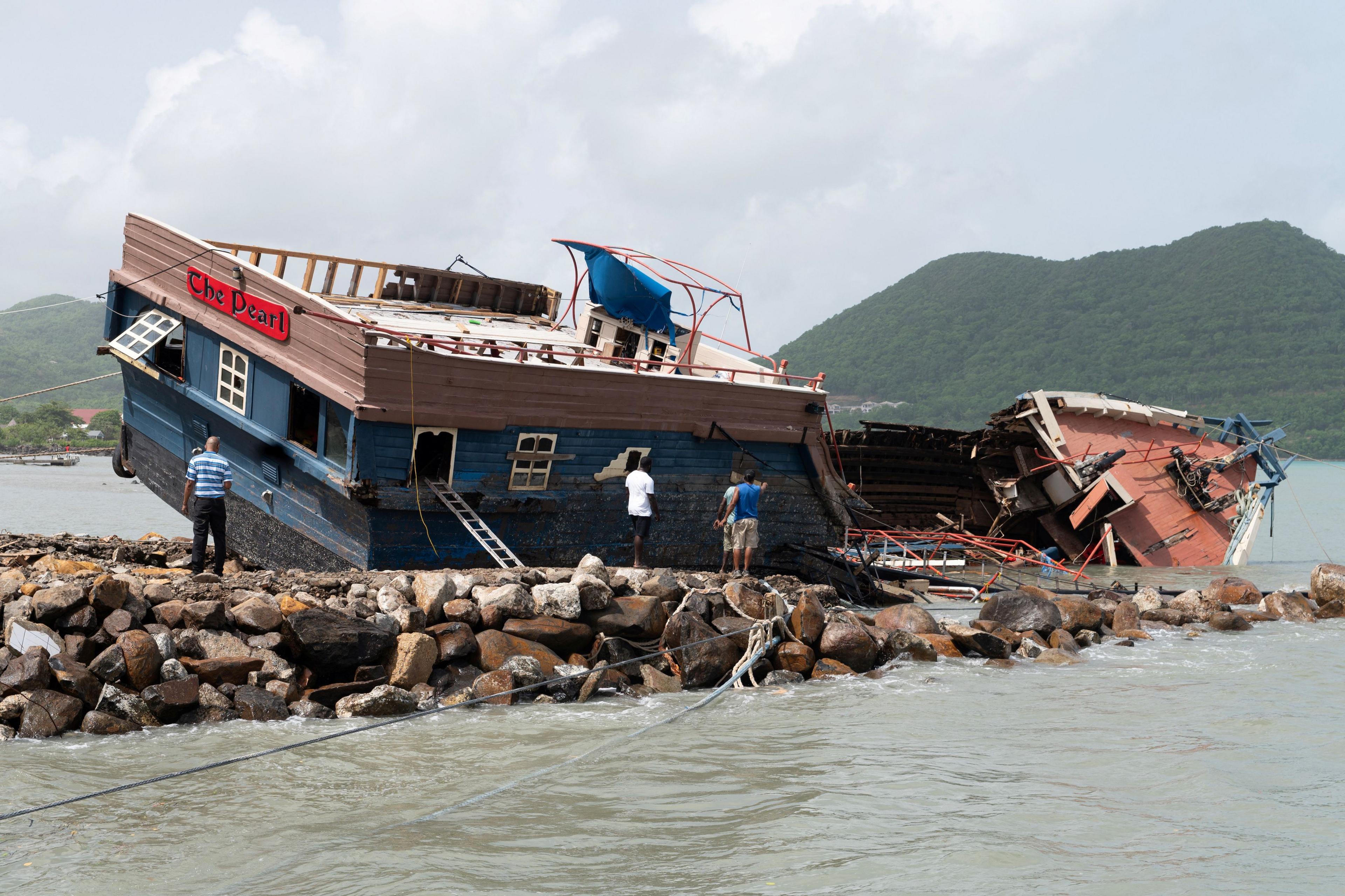 The pirate-style party boat the Pearl leans against the rocks with visible damage