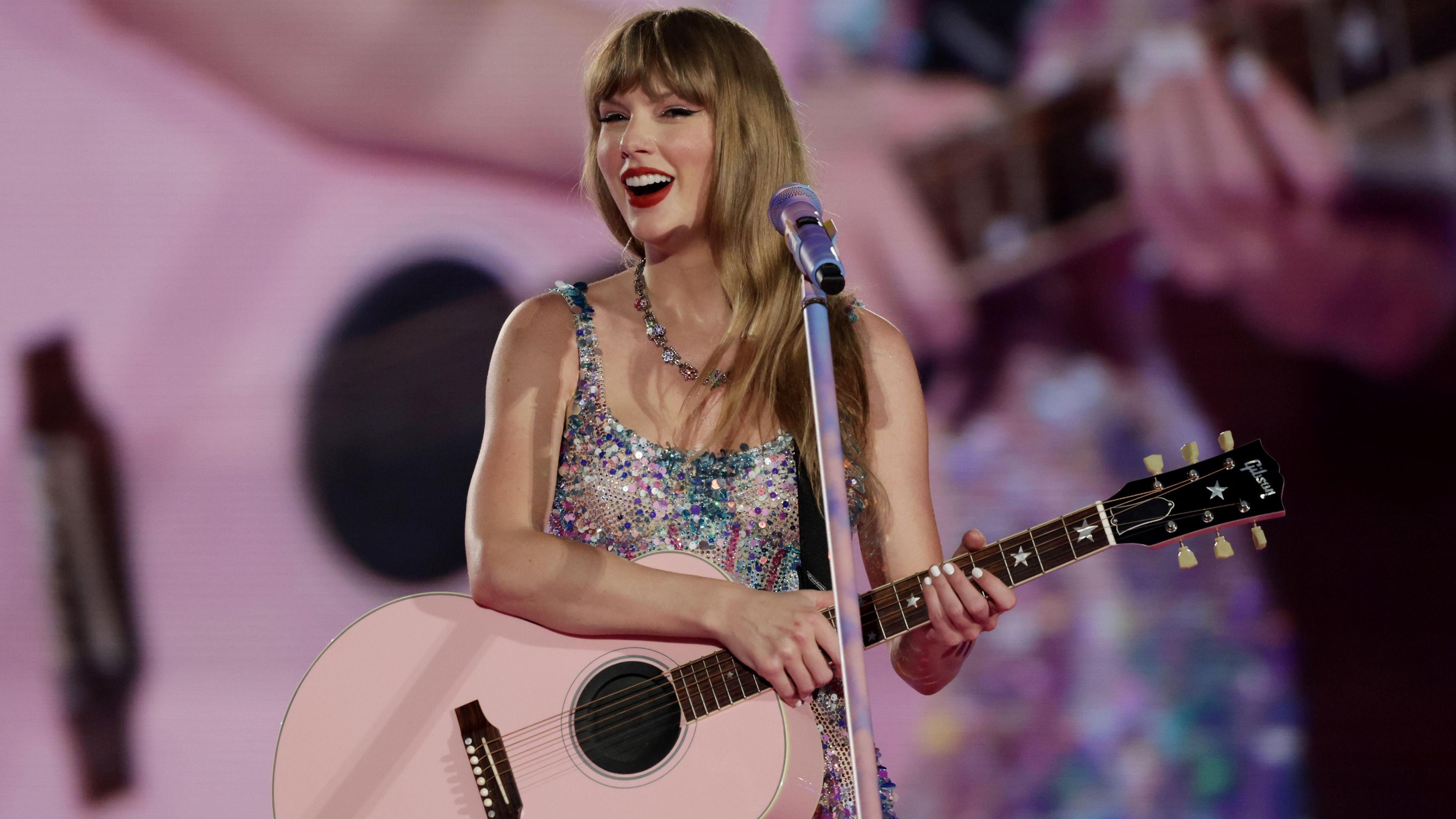 Taylor Swift holding a pink guitar