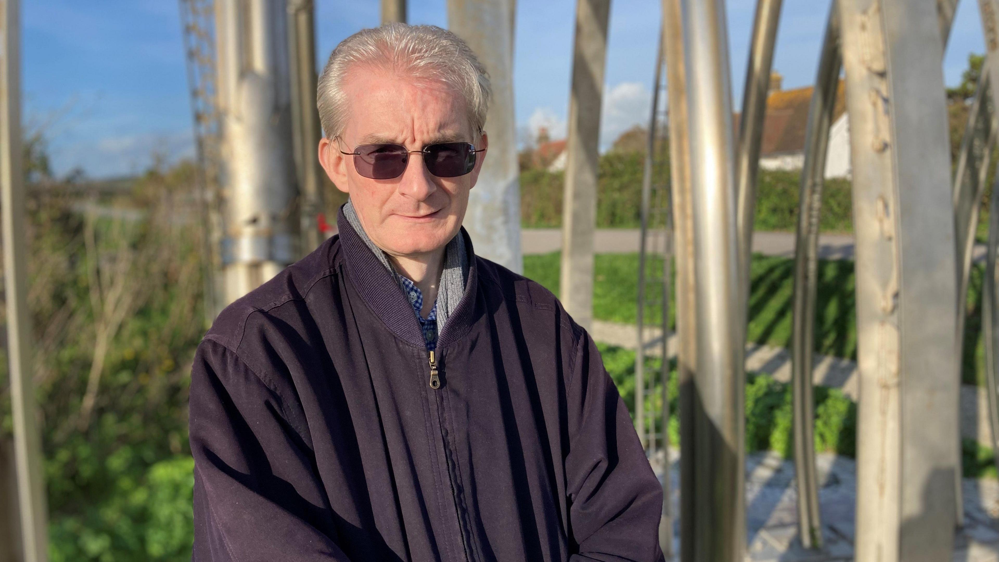 Anthony Mallinson - a man with sunglasses, grey hair and a black jacket