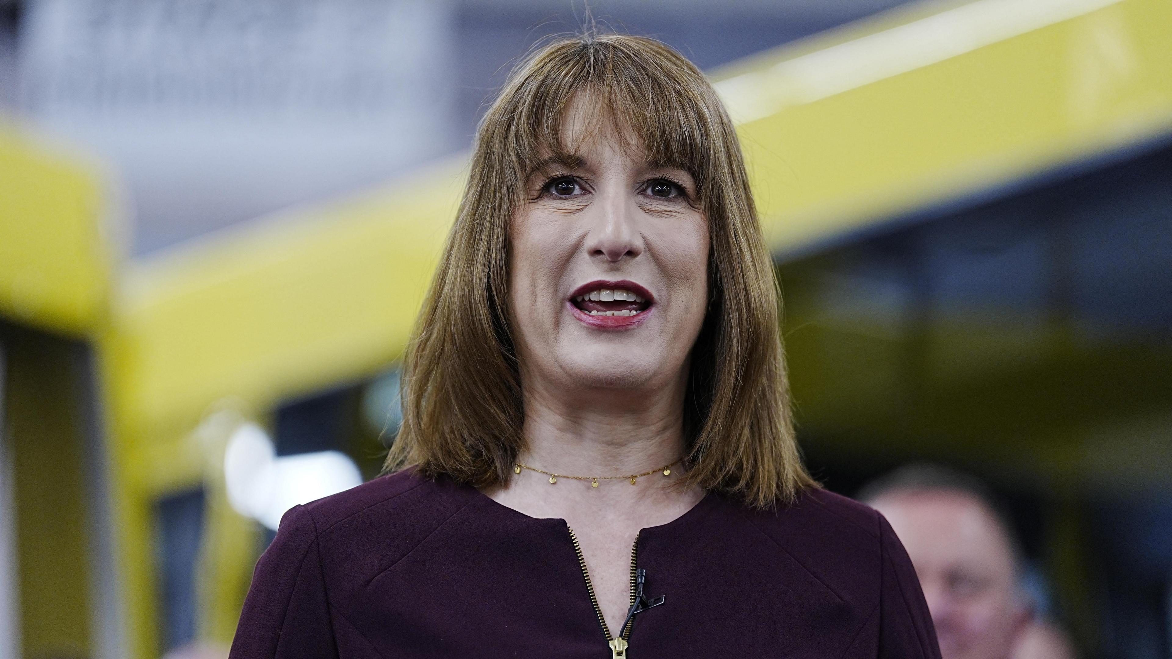 Chancellor Rachel Reeves speaks, with part of an out-of-focus bus behind her.
