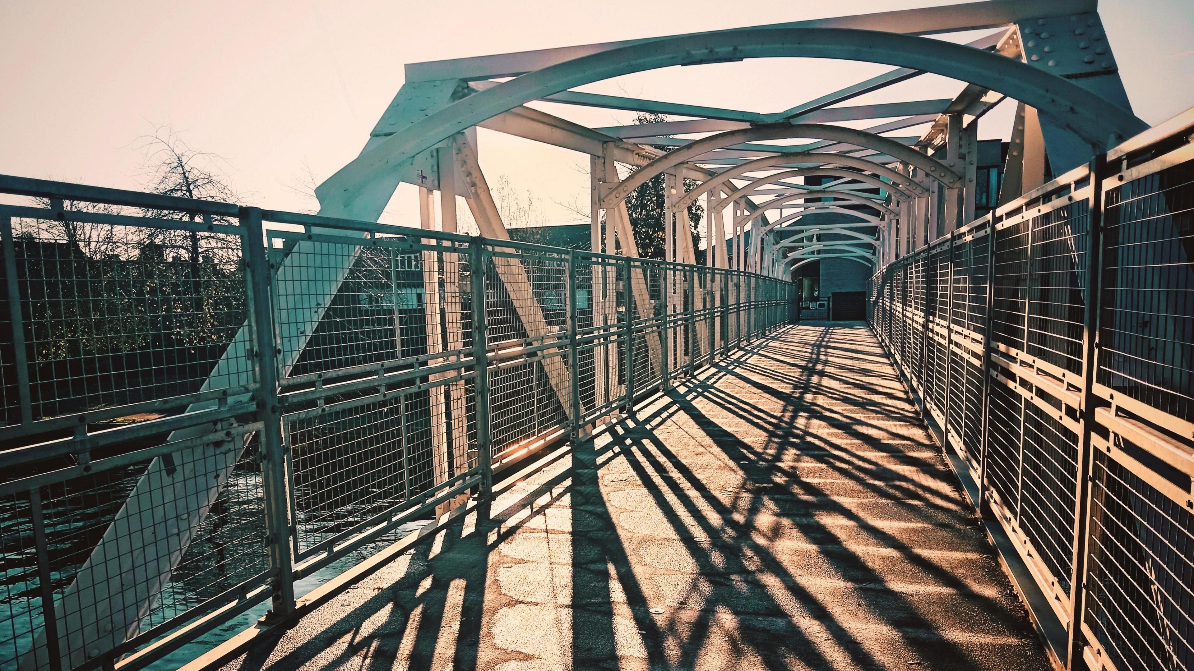 A view looking down the bridge, which is made up of metal girders which also curve over the top.