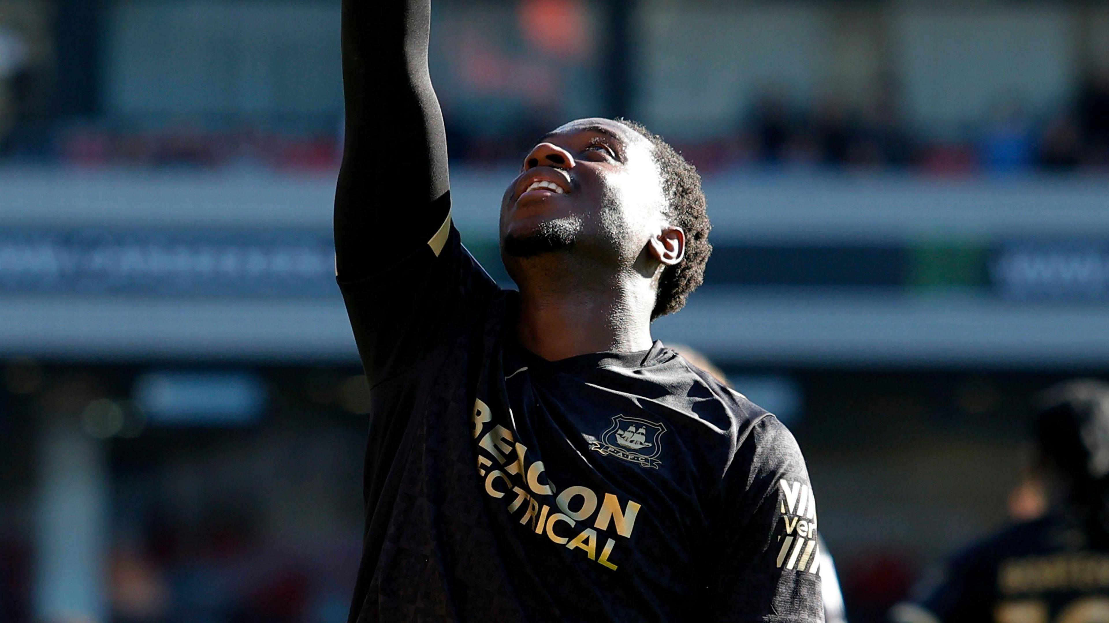 Owen Oseni celebrating by pointing with his right hand towards the sky after scoring for Plymouth Argyle.