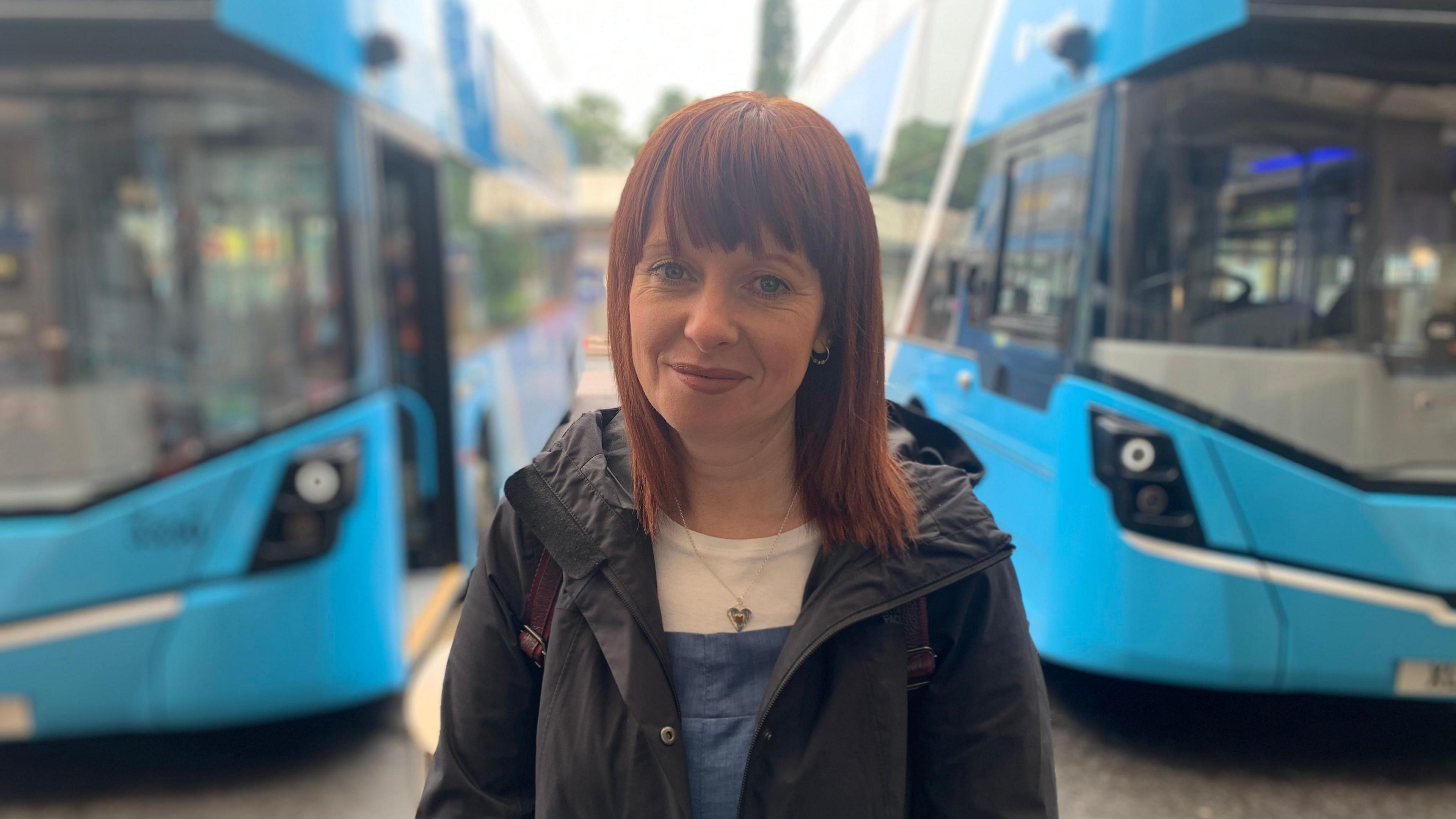 Alma White stands in front of two Translink buses 