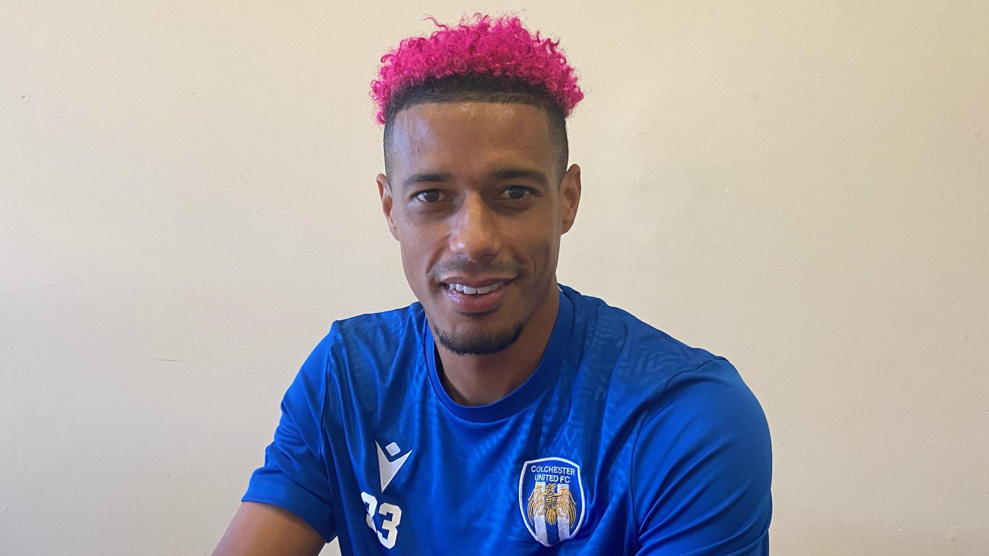 Colchester striker Lyle Taylor shows off his new pink hair