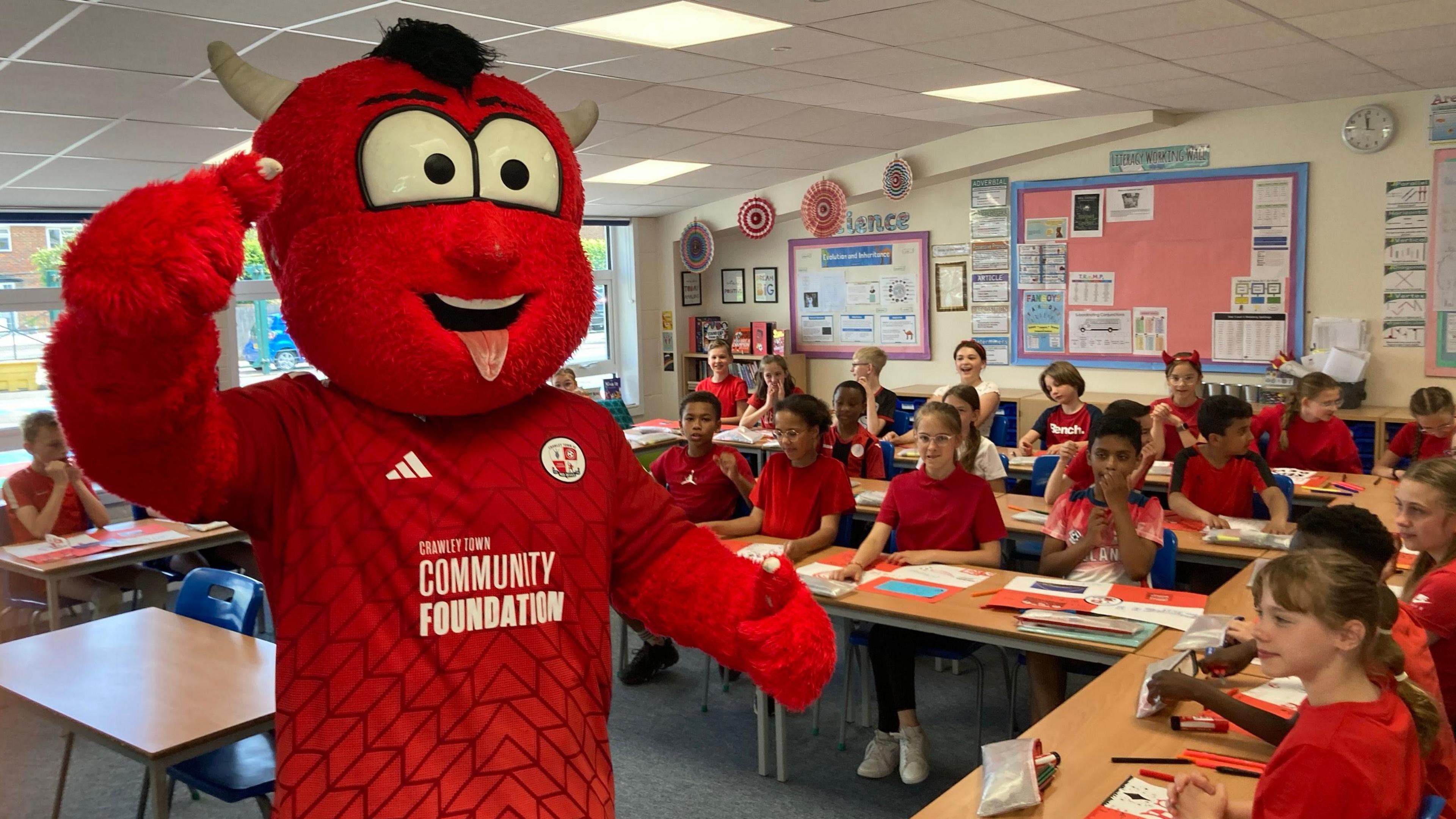 Reggie the Red in a classroom with students