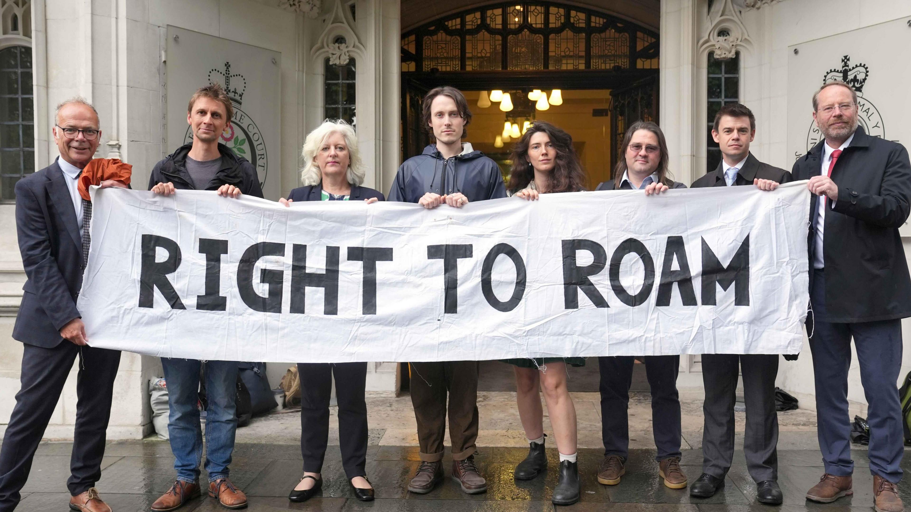 A number of people holding a banner saying right to roam.