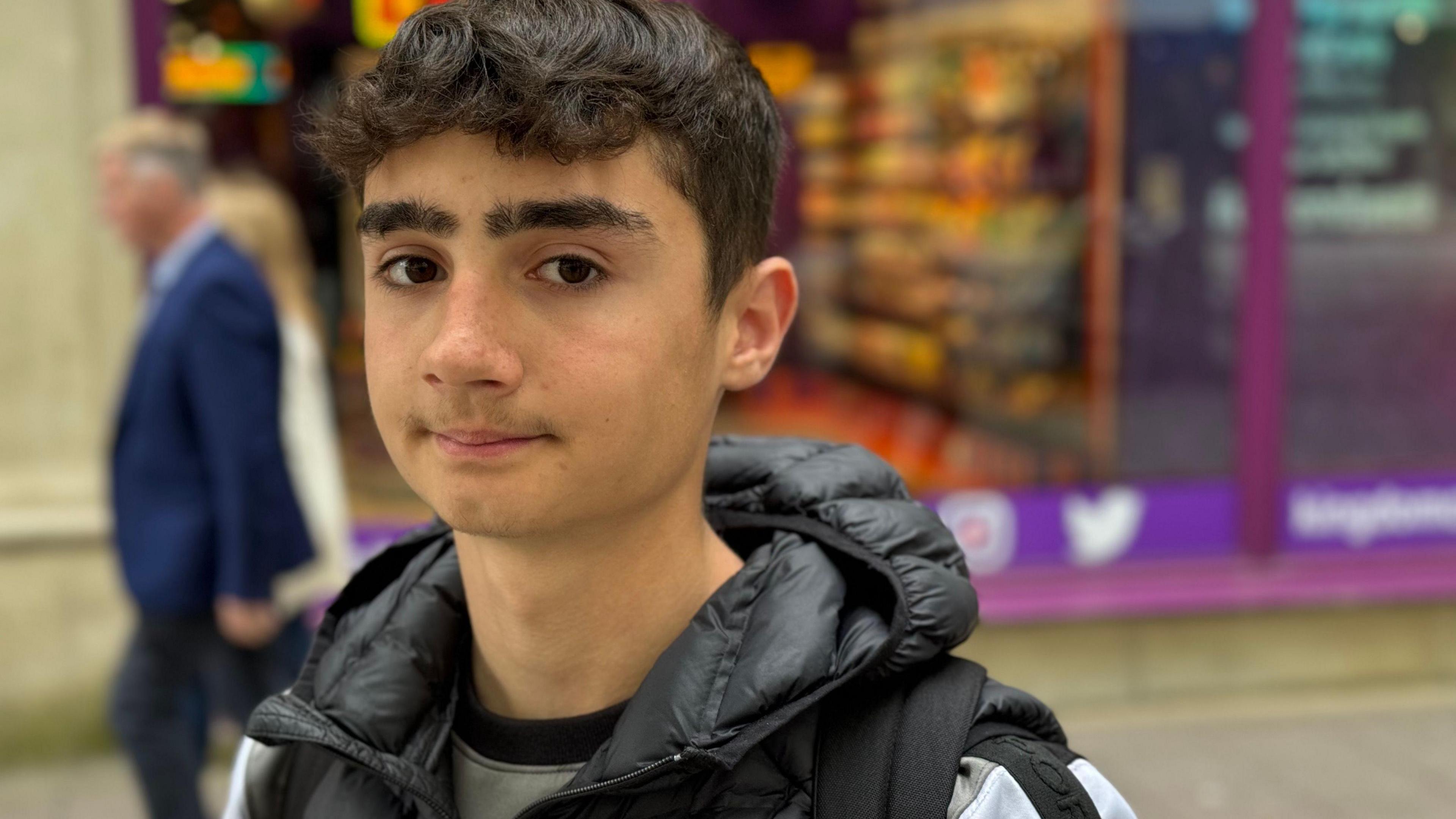 Boy in a black coat looking at the camera