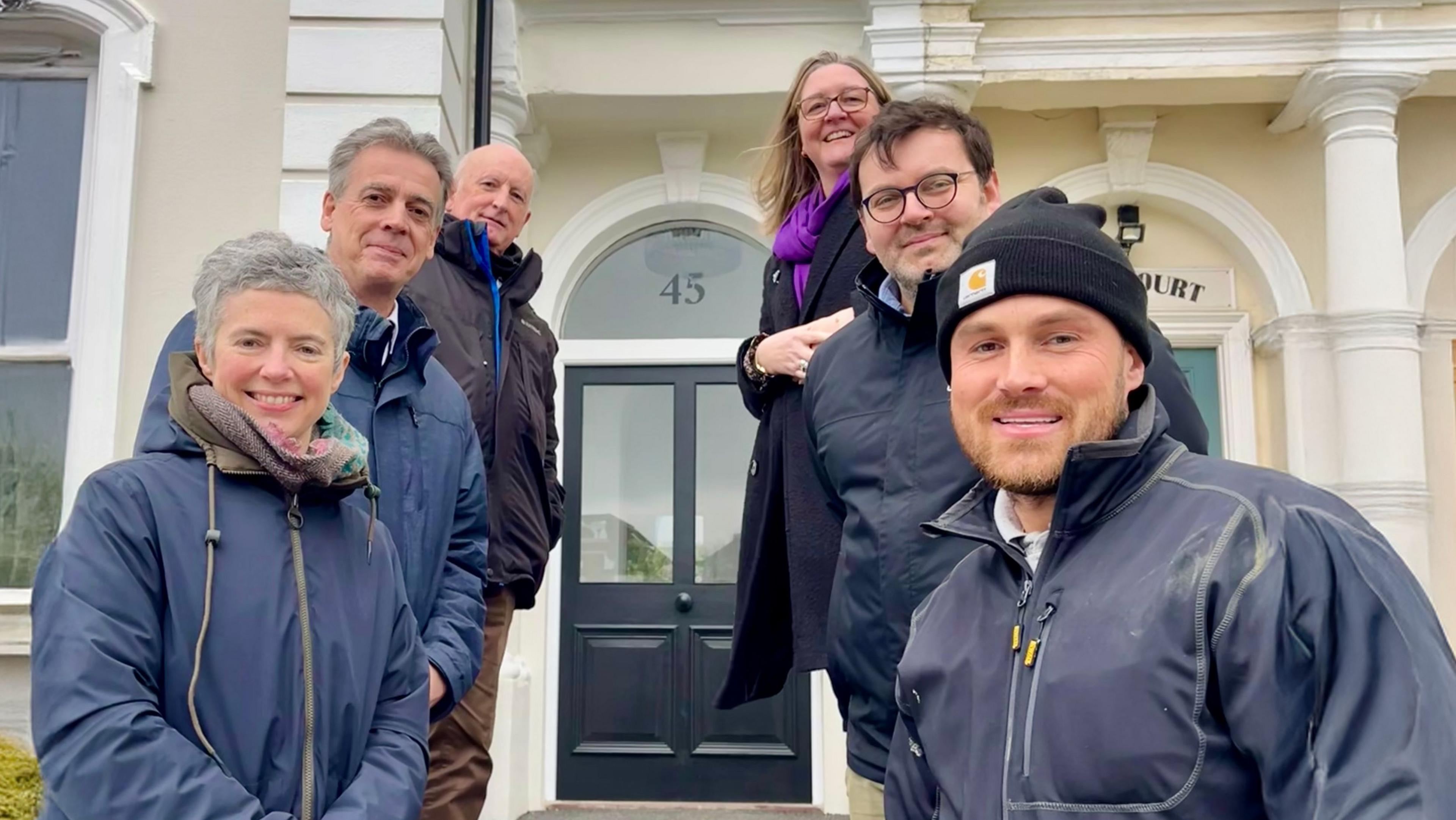 Six people standing outside a newly-refurbished home