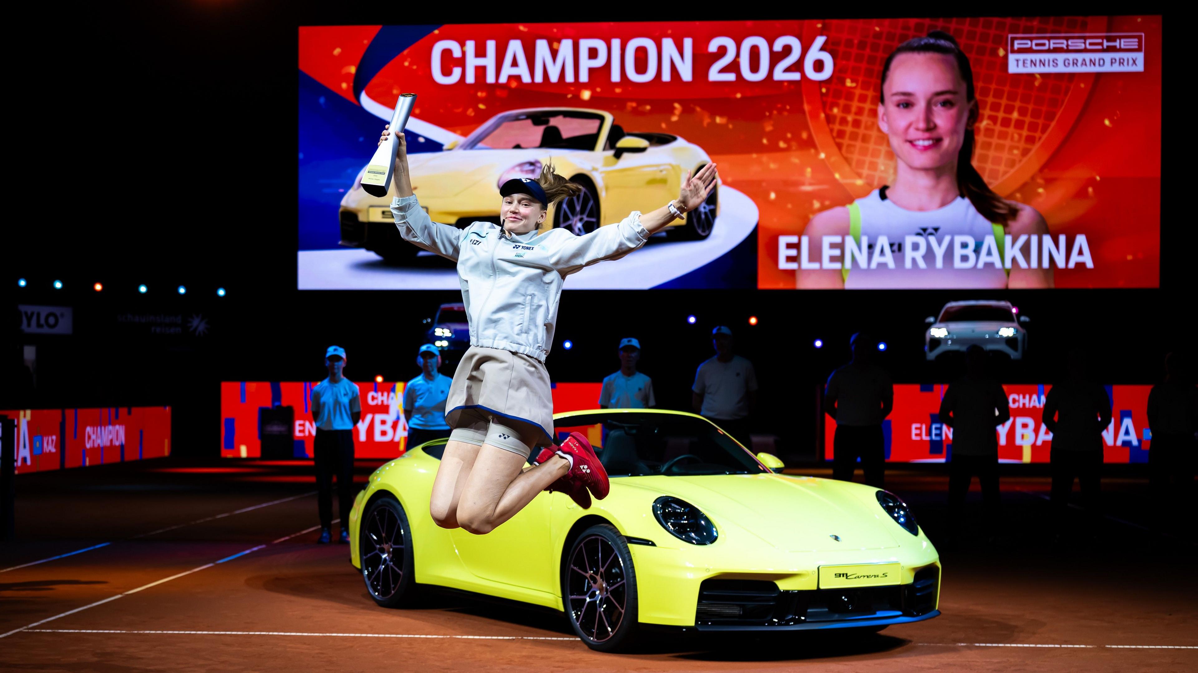 Elena Rybakina celebrates her victory in Stuttgart in front of the sports car that forms part of her winner's prize