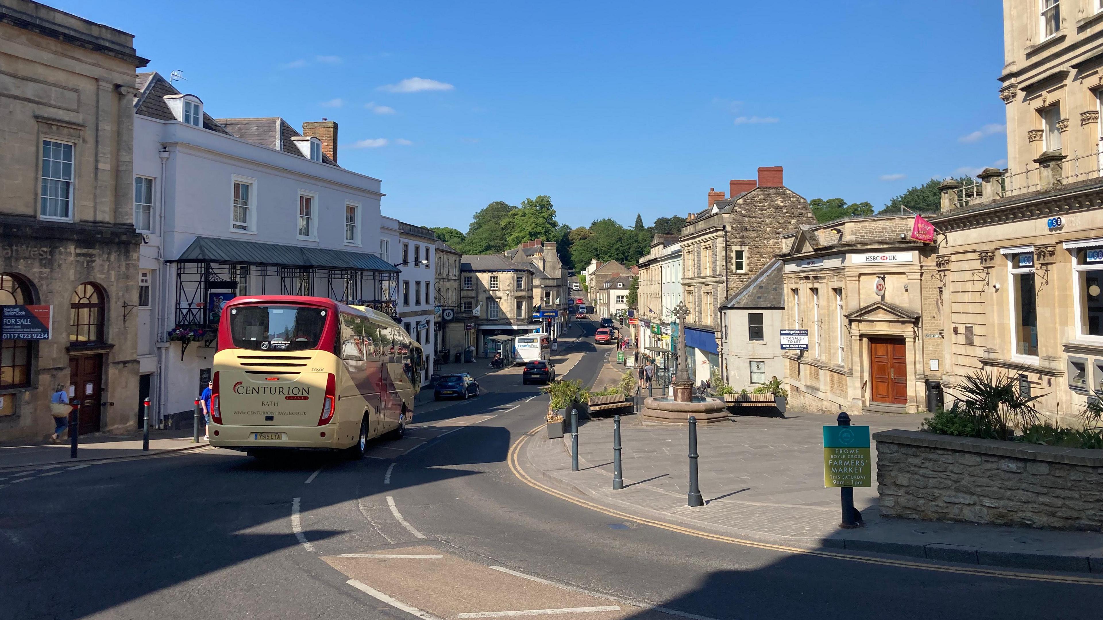 A general shot of Frome town centre taken on a sunny day.  It shows shoppers and traffic.