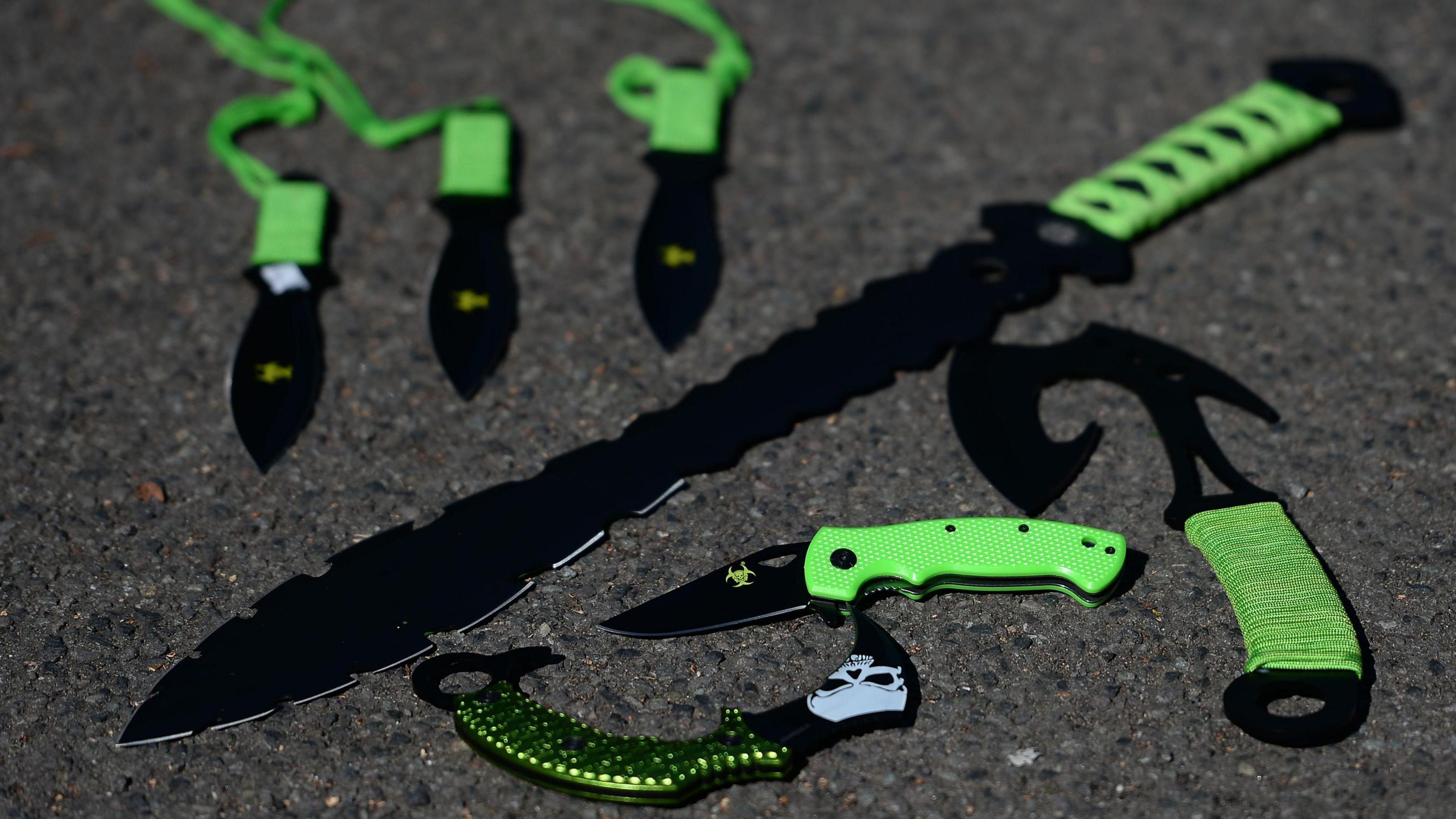 Collection of green-handled knives with jagged and curved blades