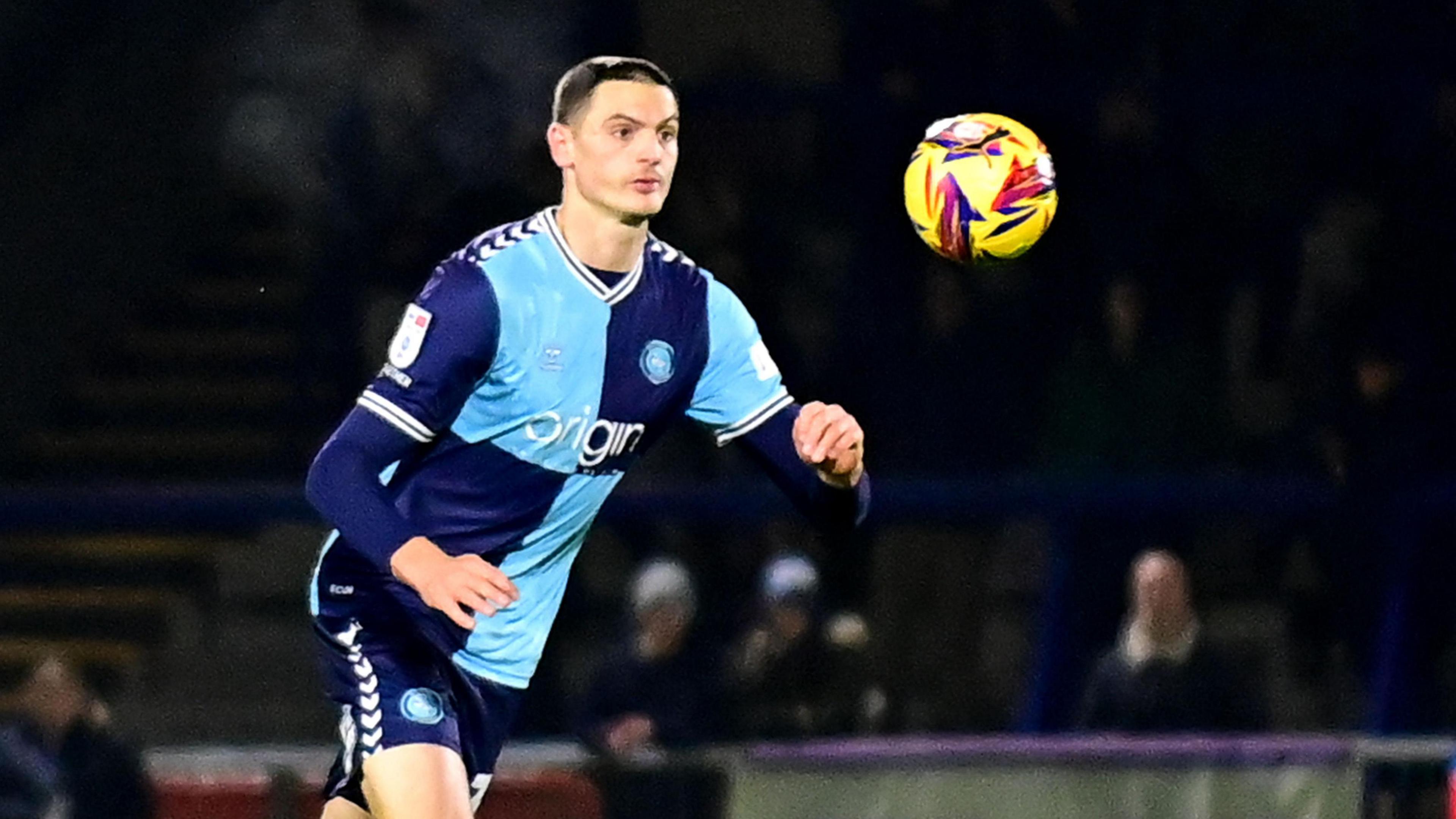 Caleb Taylor goes to control the ball whilst playing for Wycombe Wanderers