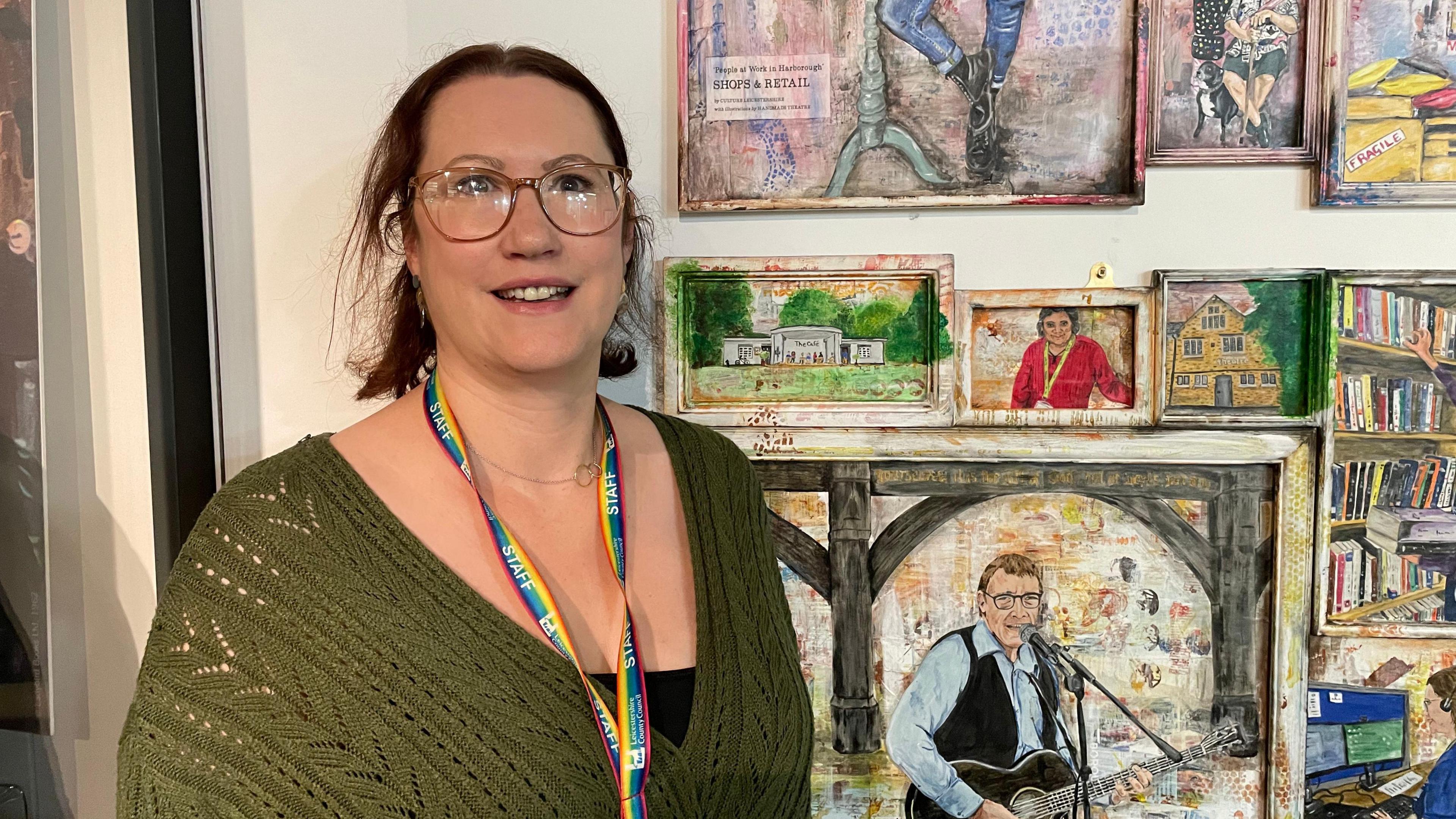 Helen Murray in green top standing in front of mural