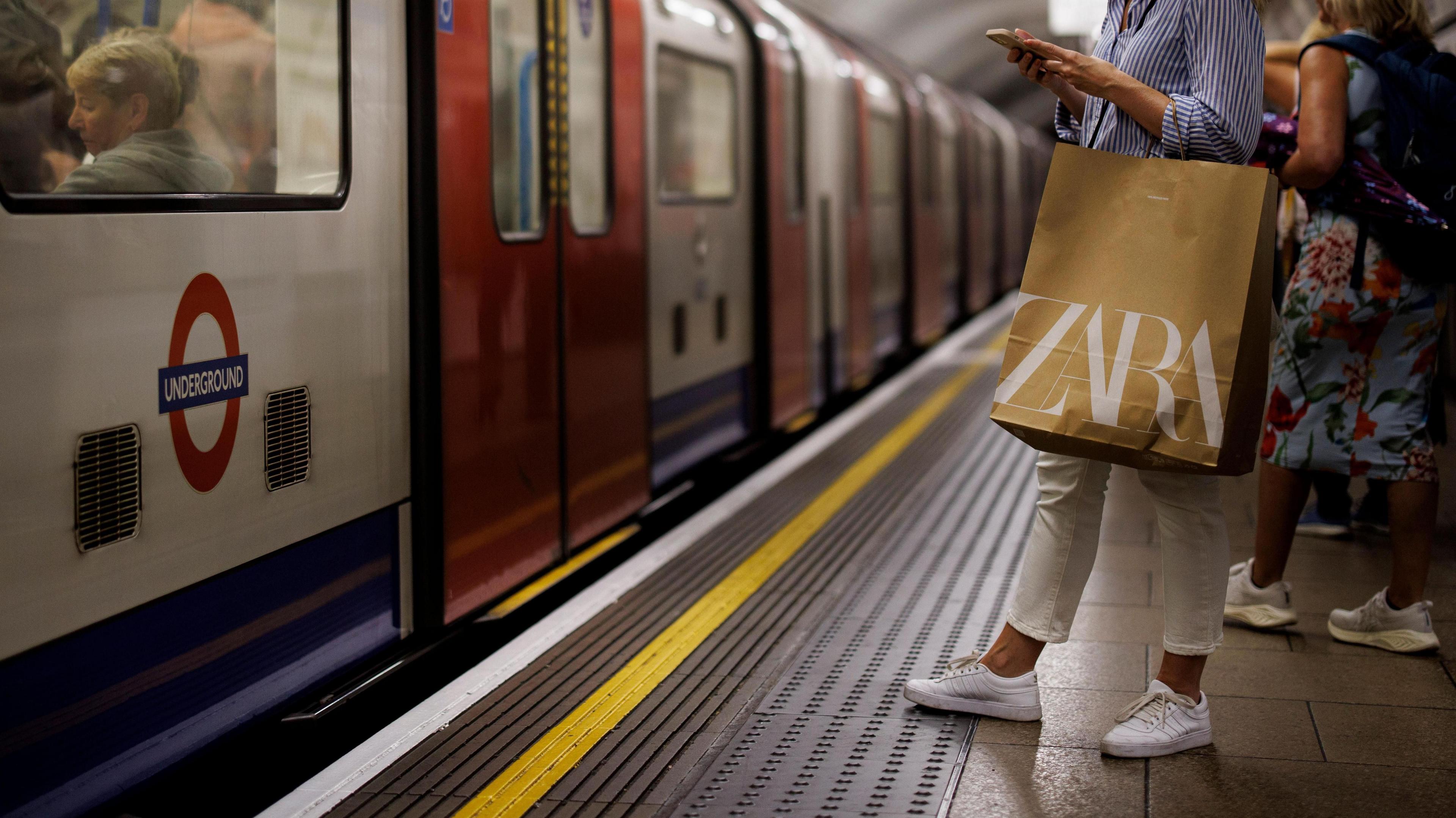 File photo of an anonymous woman on her phone as she waits for a Tube train to pull into a platform