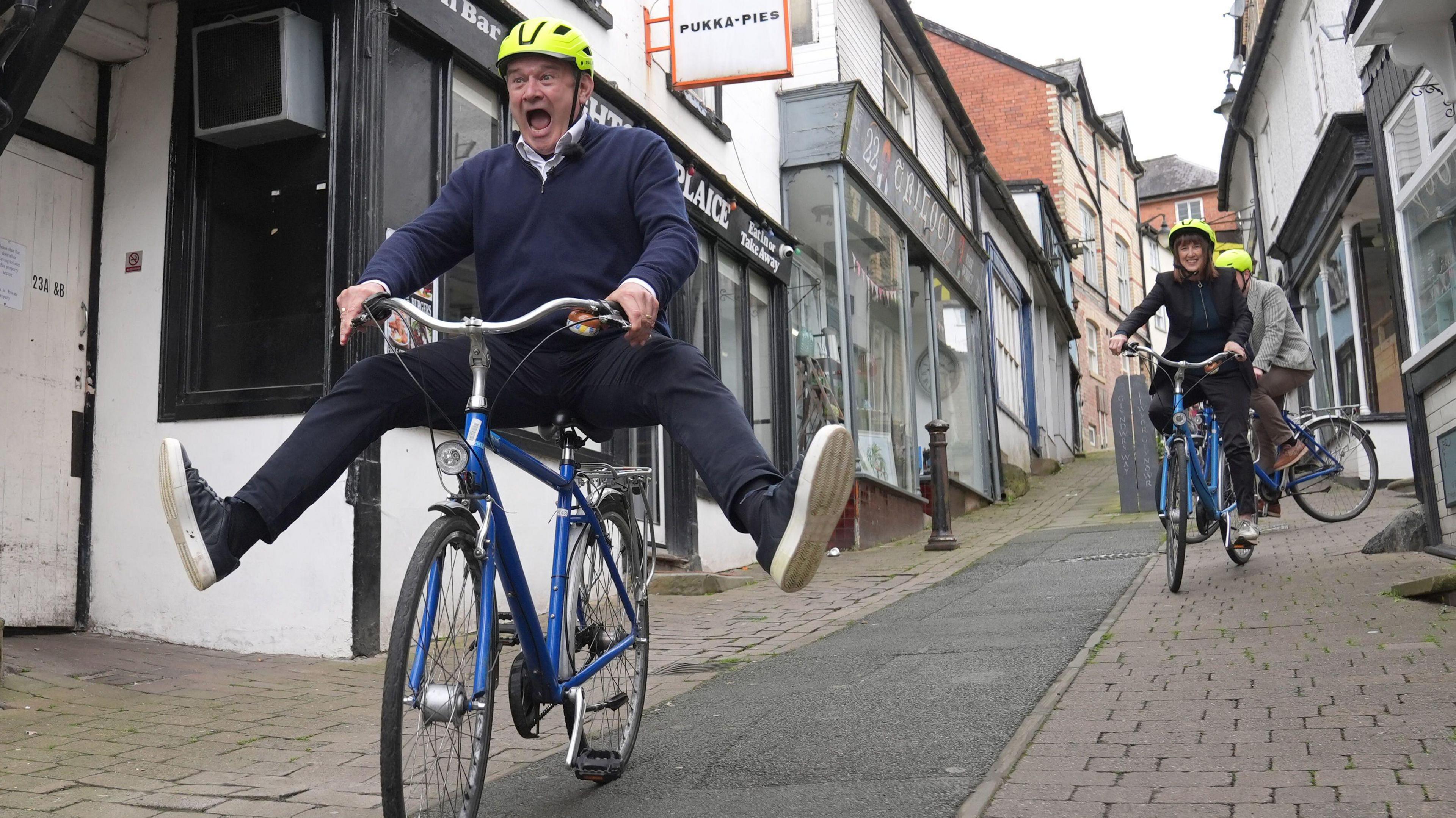 Liberal Democrat Leader Sir Ed Davey riding a bike during a visit to Knighton, Powys