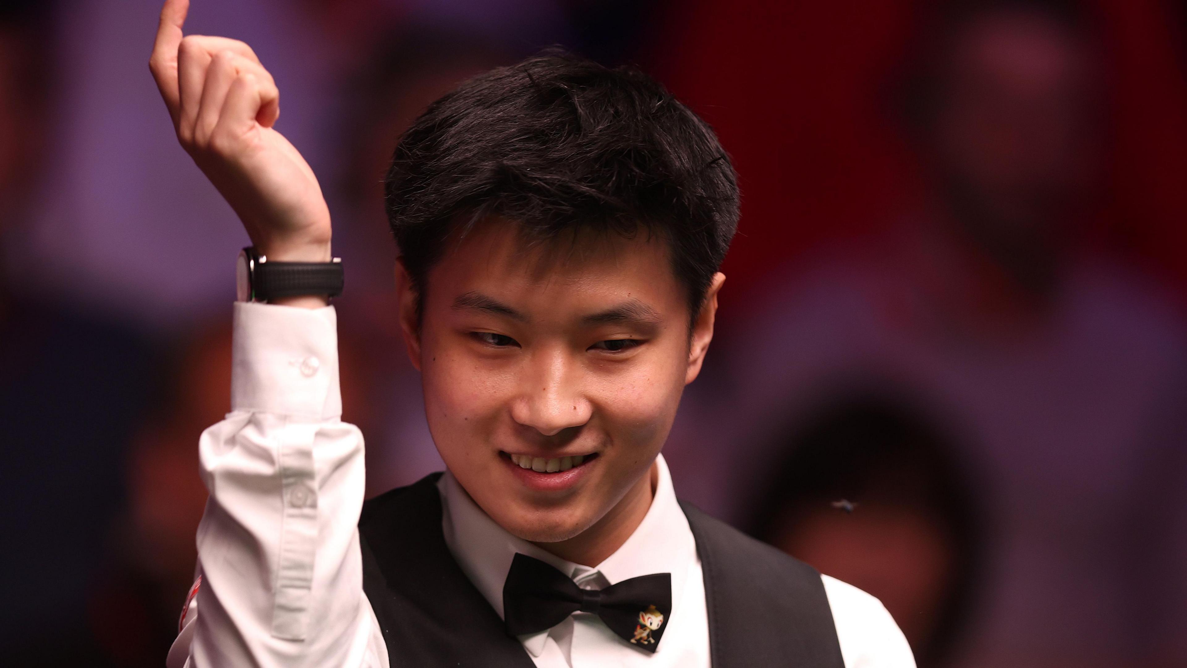 Zhao Xintong smiles while raising his arm