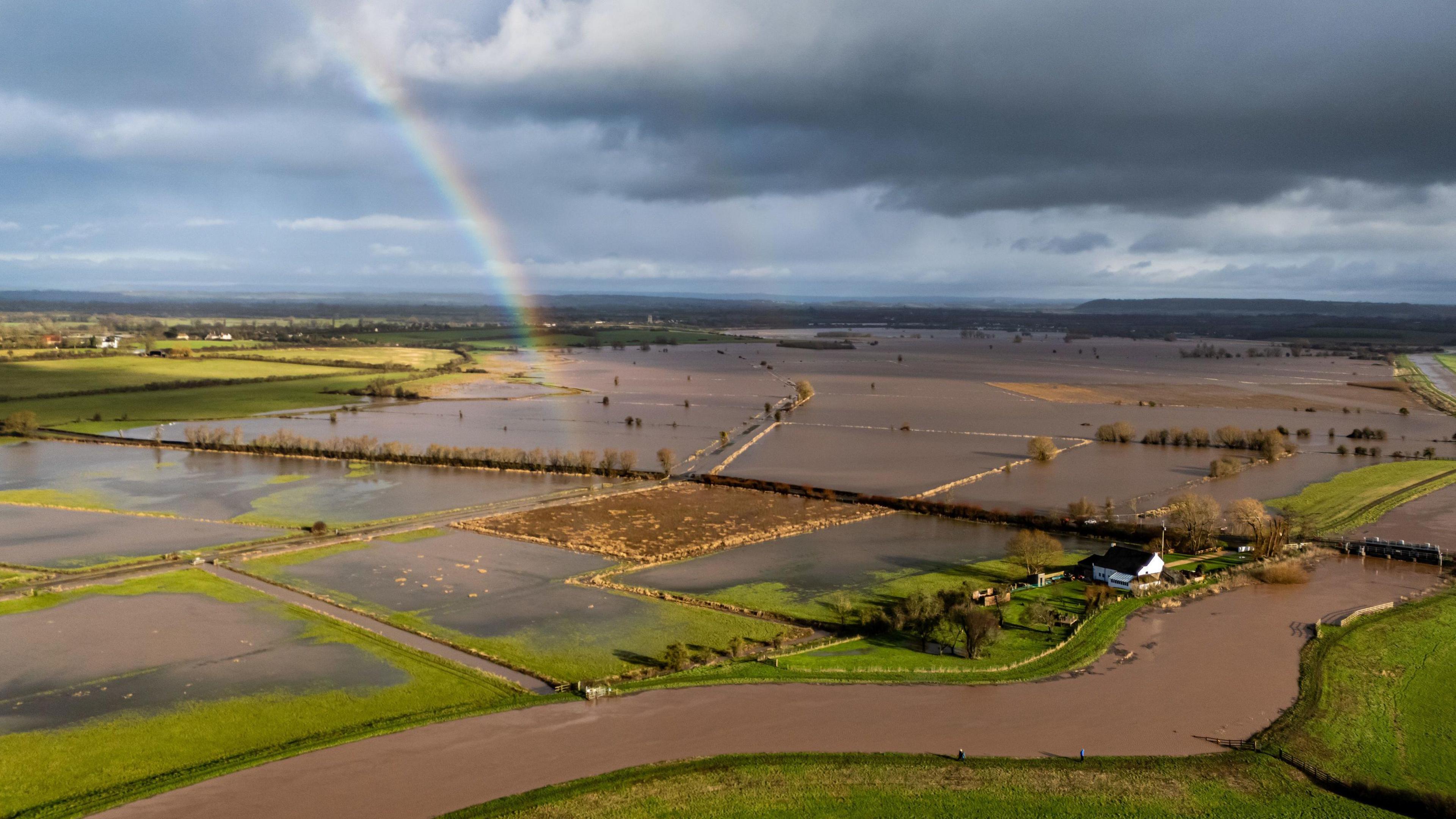 Aerial view of flooded fields with a rainbow overhead
