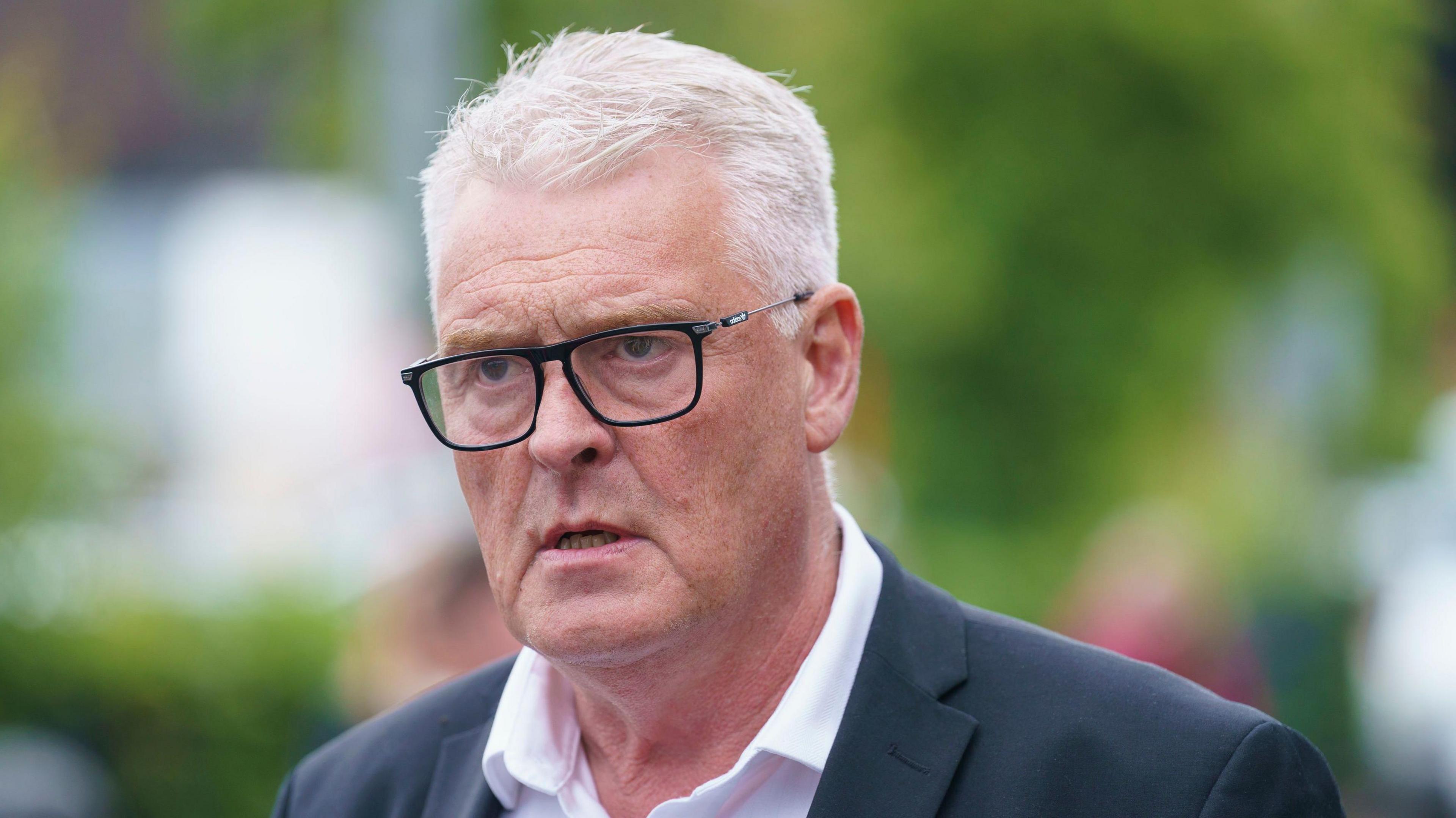 Reform MP Lee Anderson wears glasses, a grey suit jacket and a white shirt.