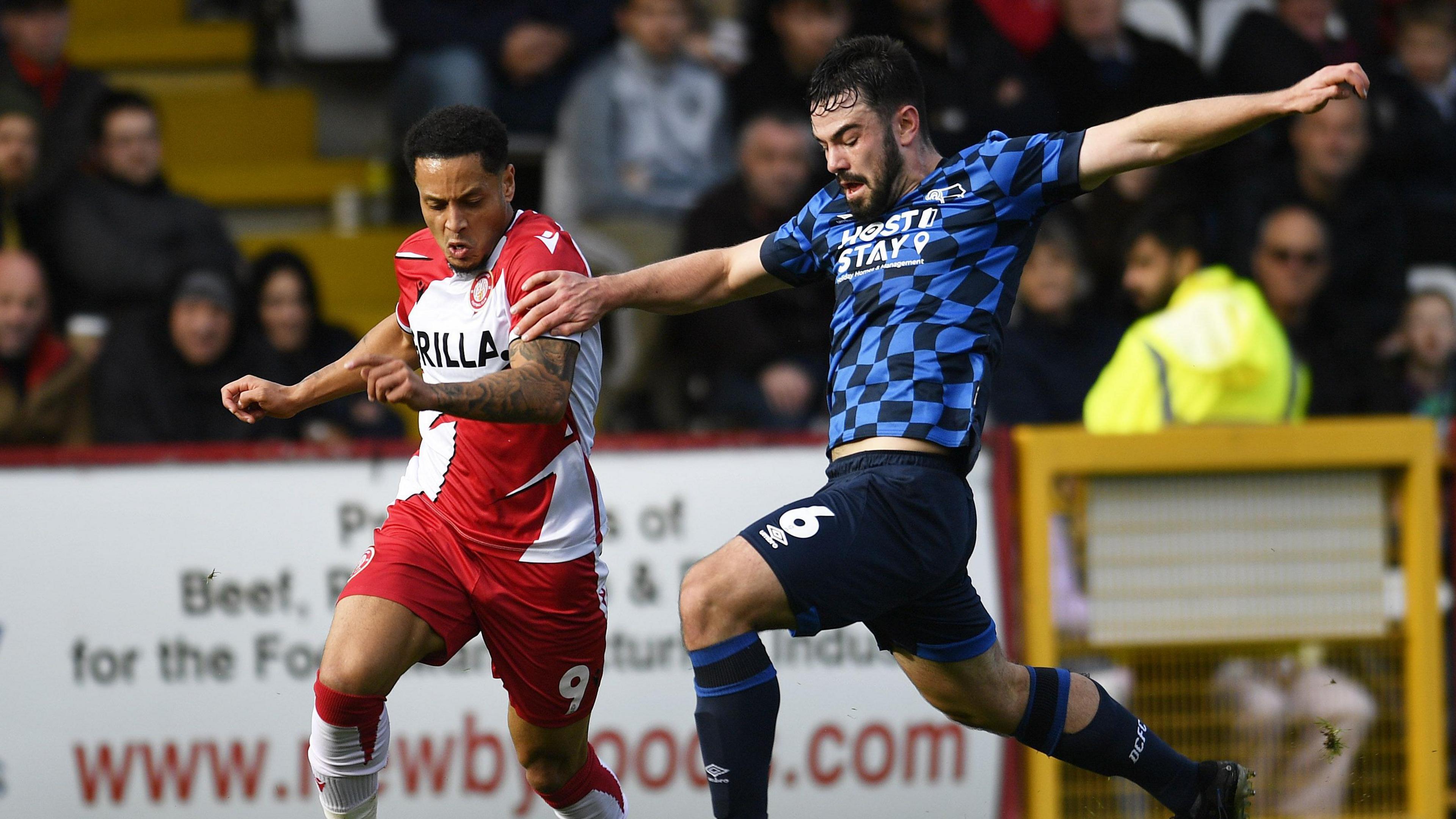 Stevenage's Elliott List battles with Eirin Cashin of Derby 