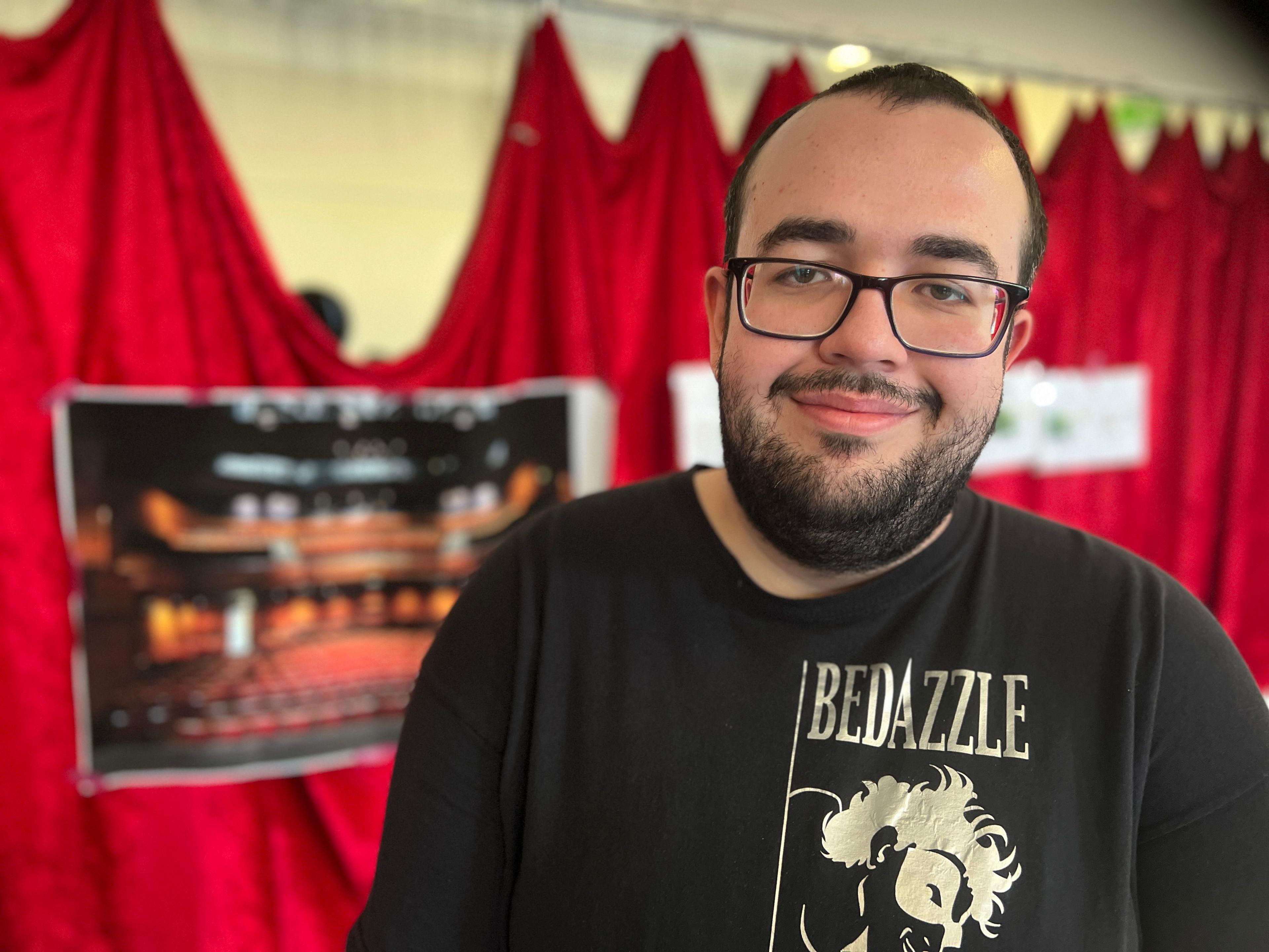 Actor standing in front of an image of the stage 