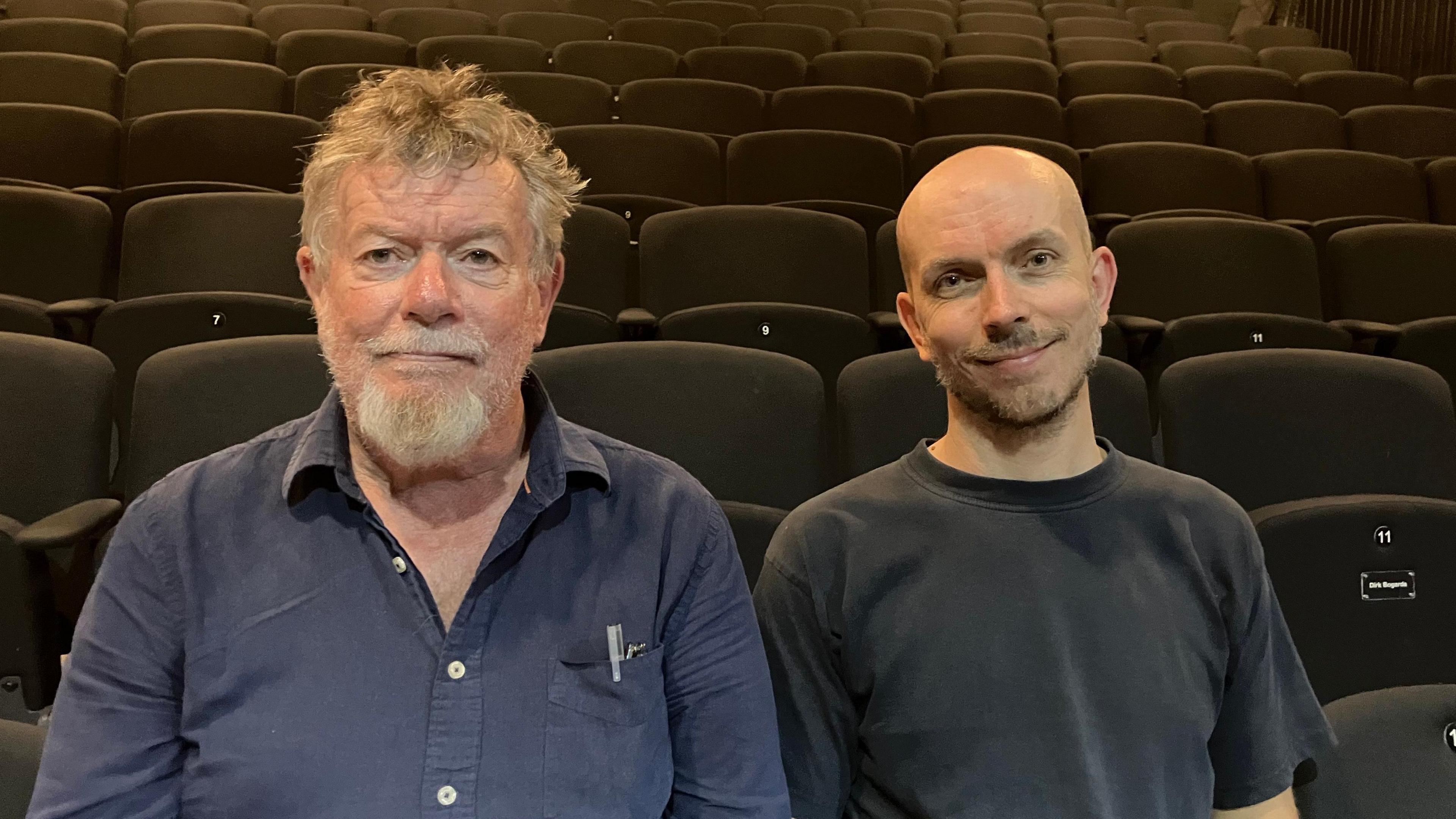 Rob John and Merlyn Haycroft sit on chairs in a theatre
