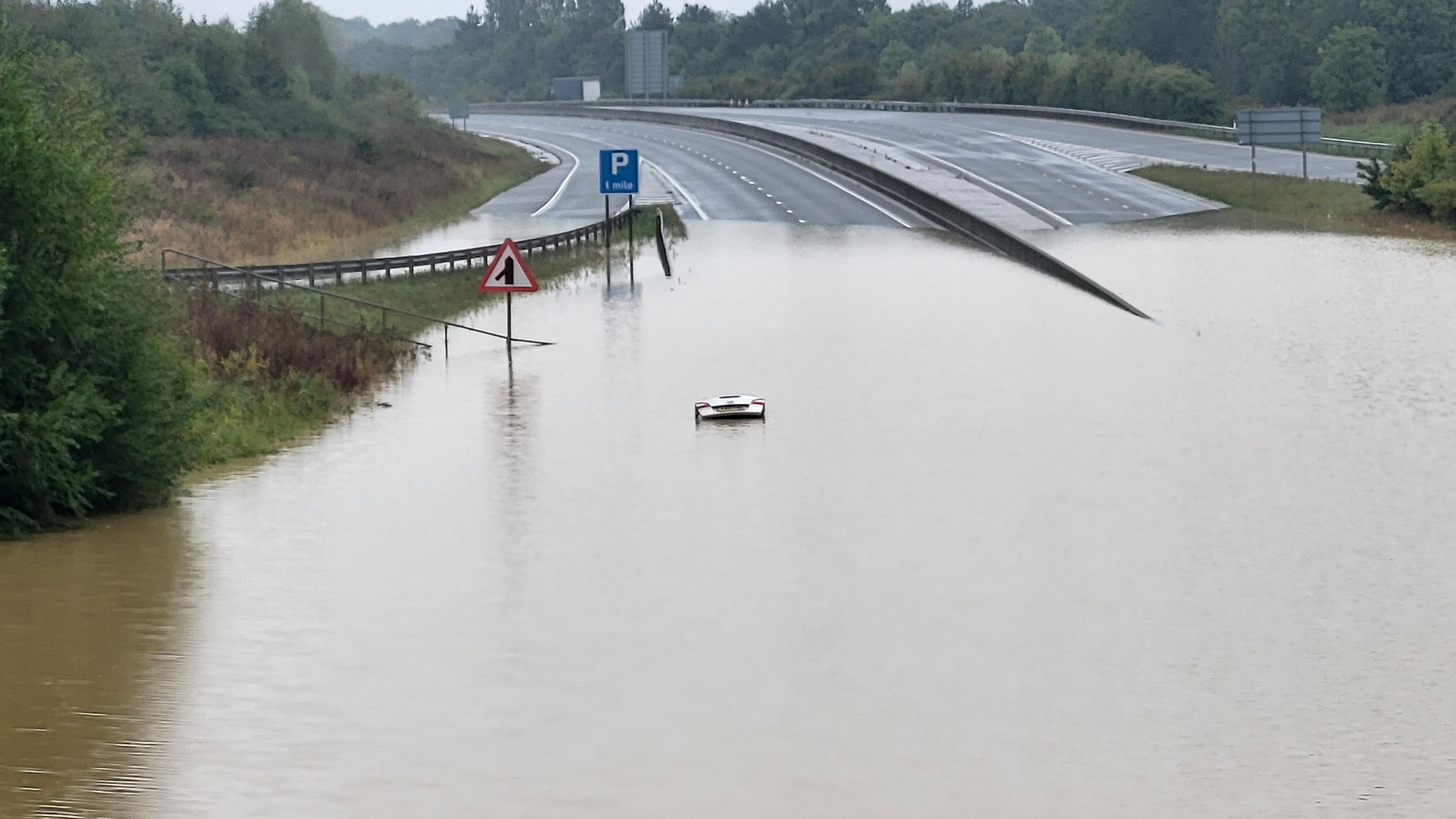 The boot of a car visible above the water on a flooded dip on the A421 between Bedford and Milton Keynes.