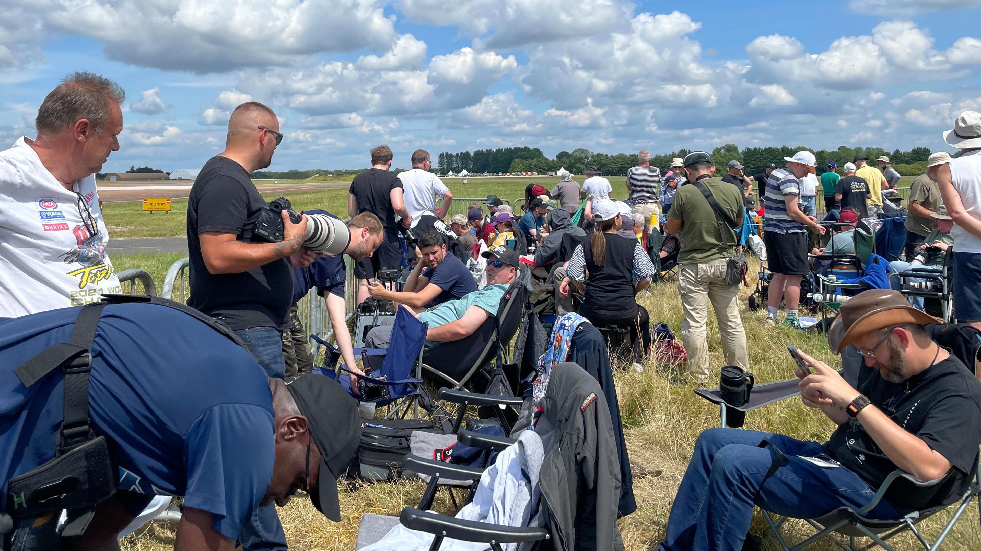 Crowds of plane enthusiasts, many with long lens cameras gathered on the edge of the runway at RAF Fairford