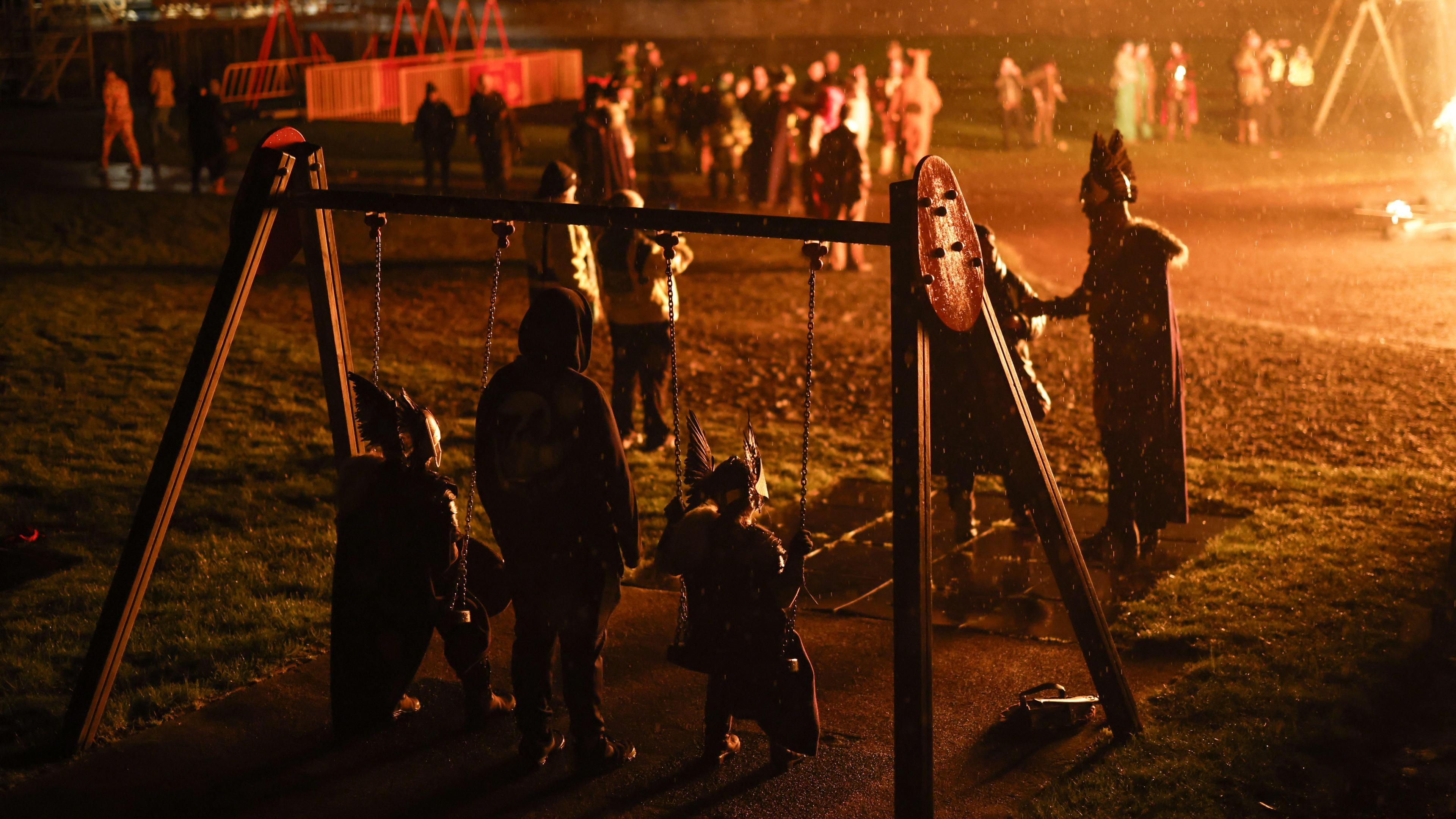 people in viking costume on a swing set 