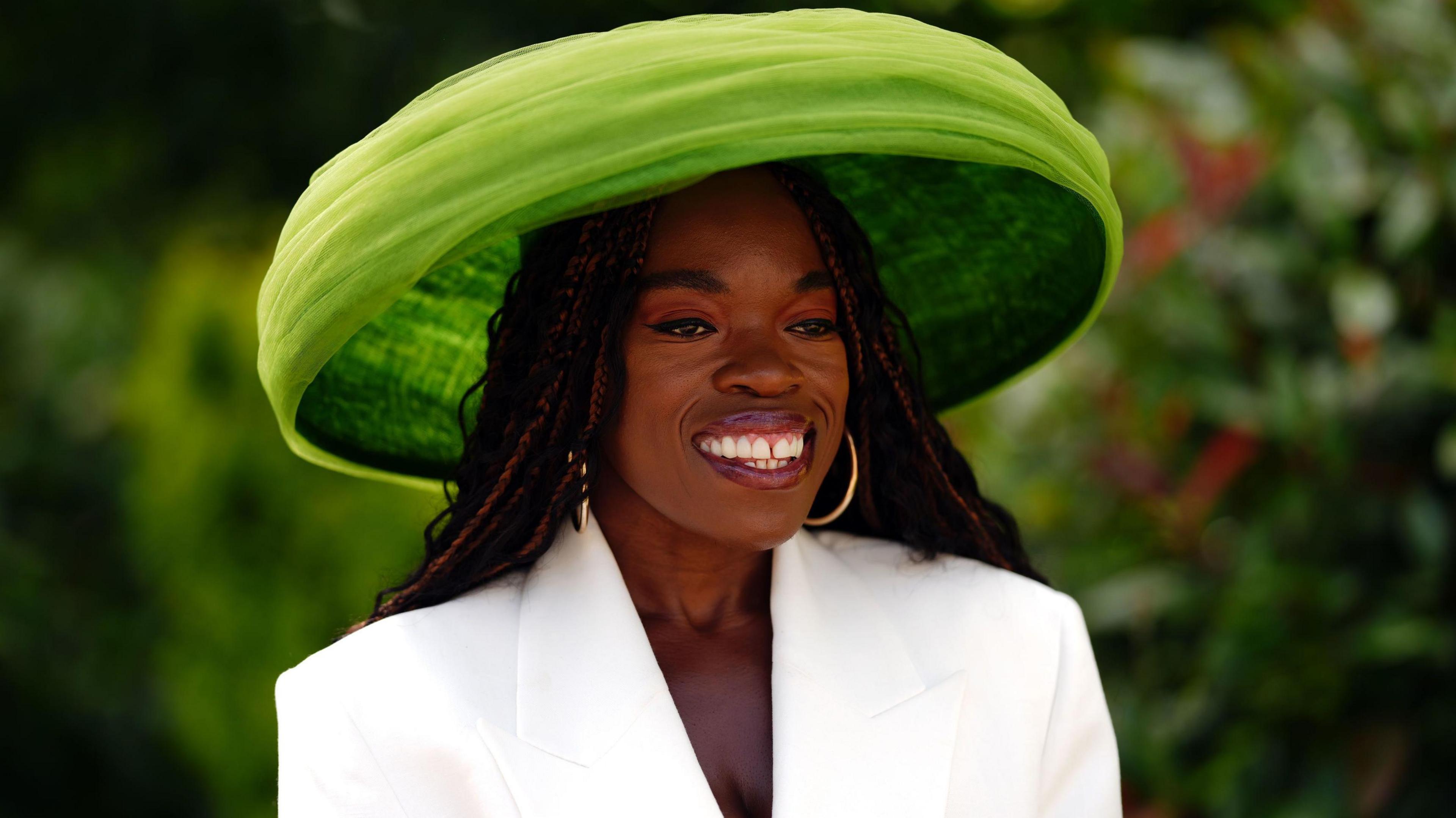 Nana Acheampong sports a white brimmed bright green hat