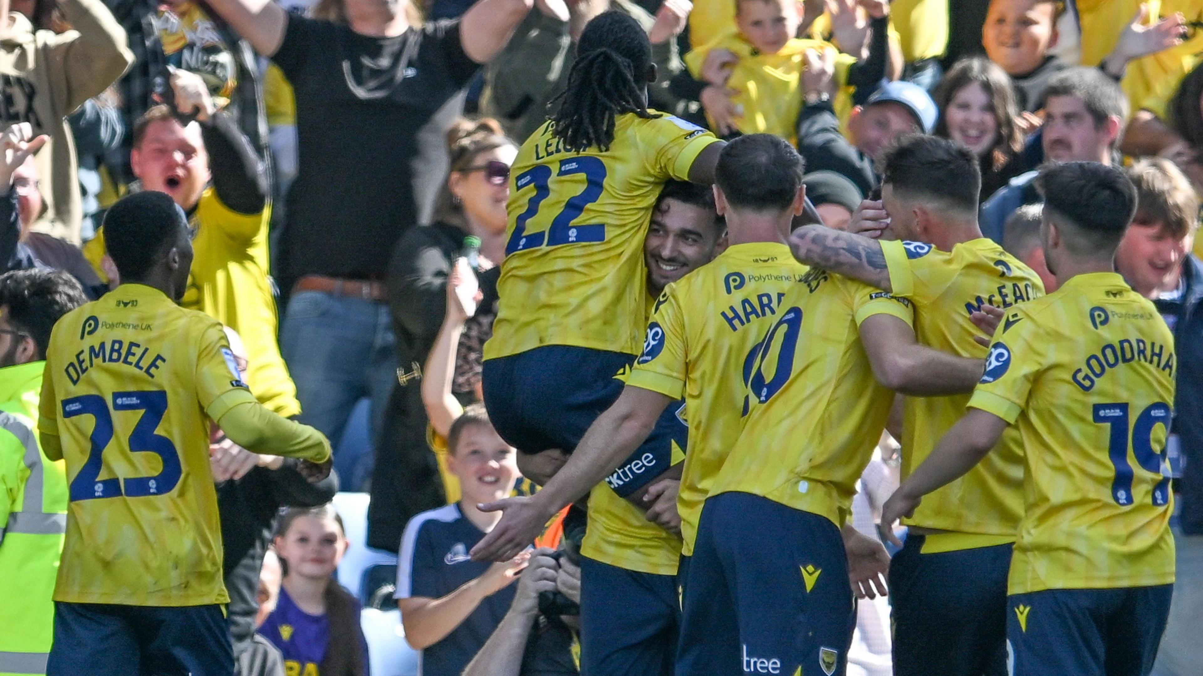  Idris El Mizouni is jumped on by his Oxford United team-mates after scorning the winning goal against Stoke City