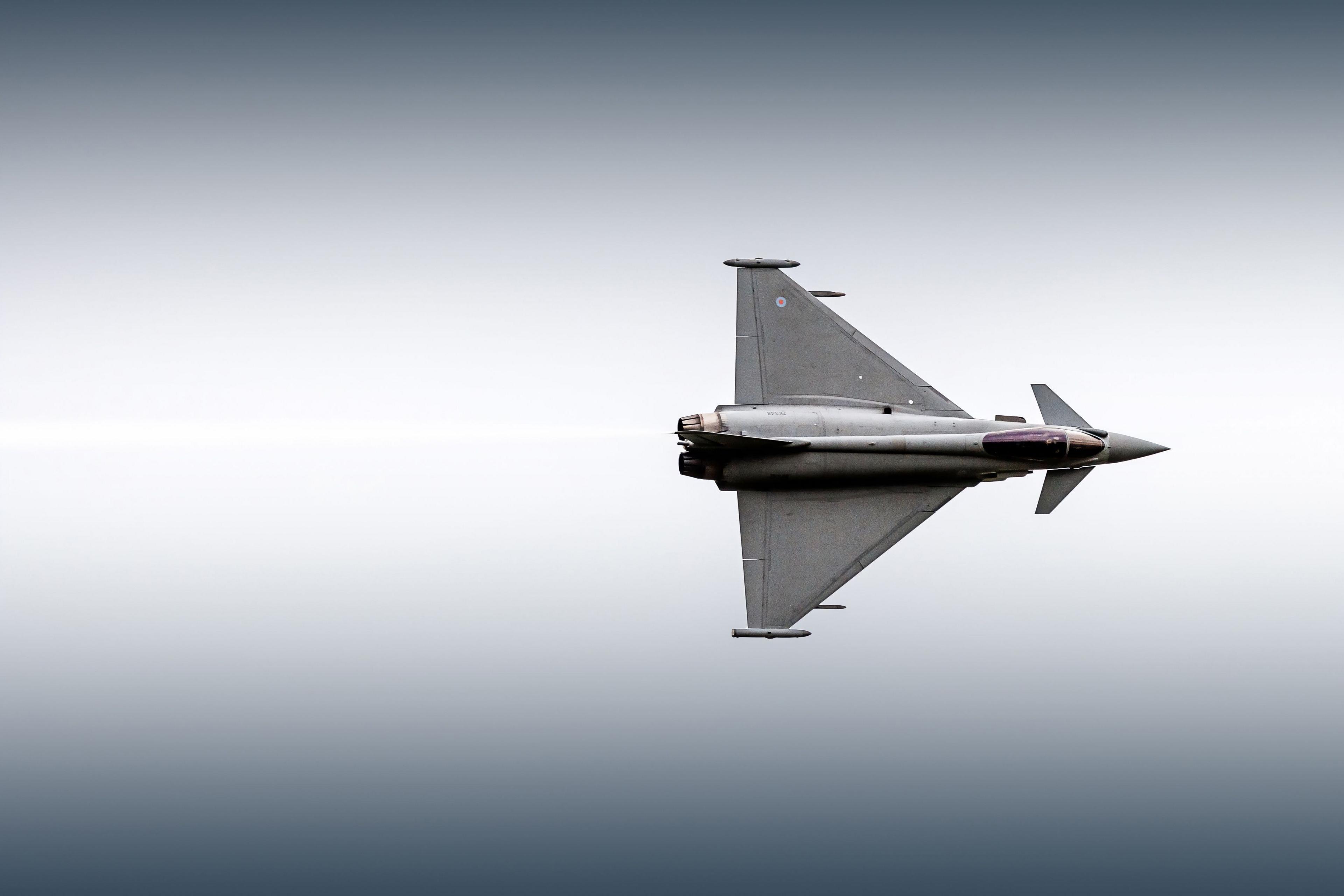 A grey typhoon to the right of the picture,  against a grey sky.  The plane is on its side.