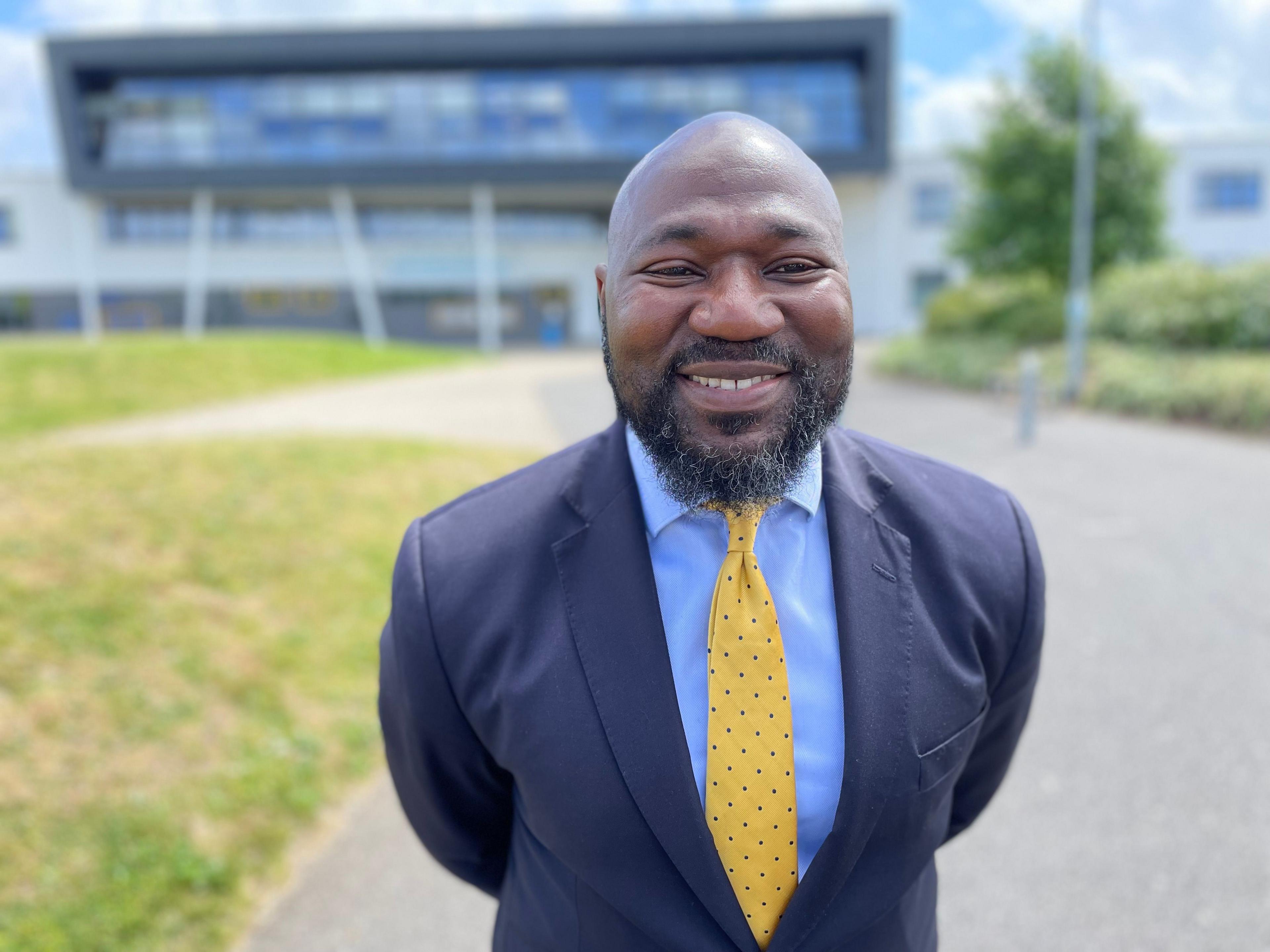 Conservative candidate Festus Akinbusoye in a dark blue suit, light blue shirt and yellow tie