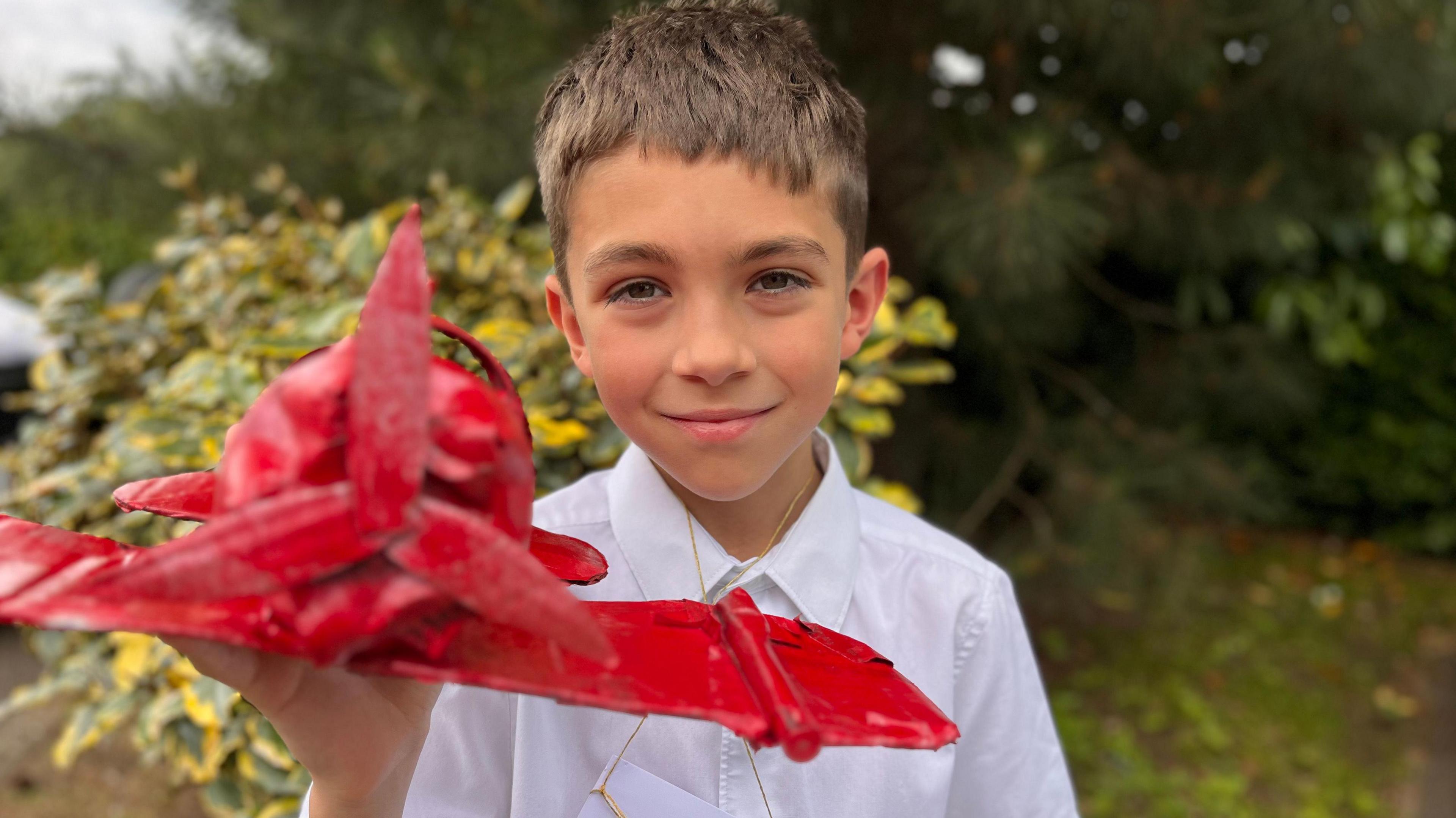 Boy holding red model of plane