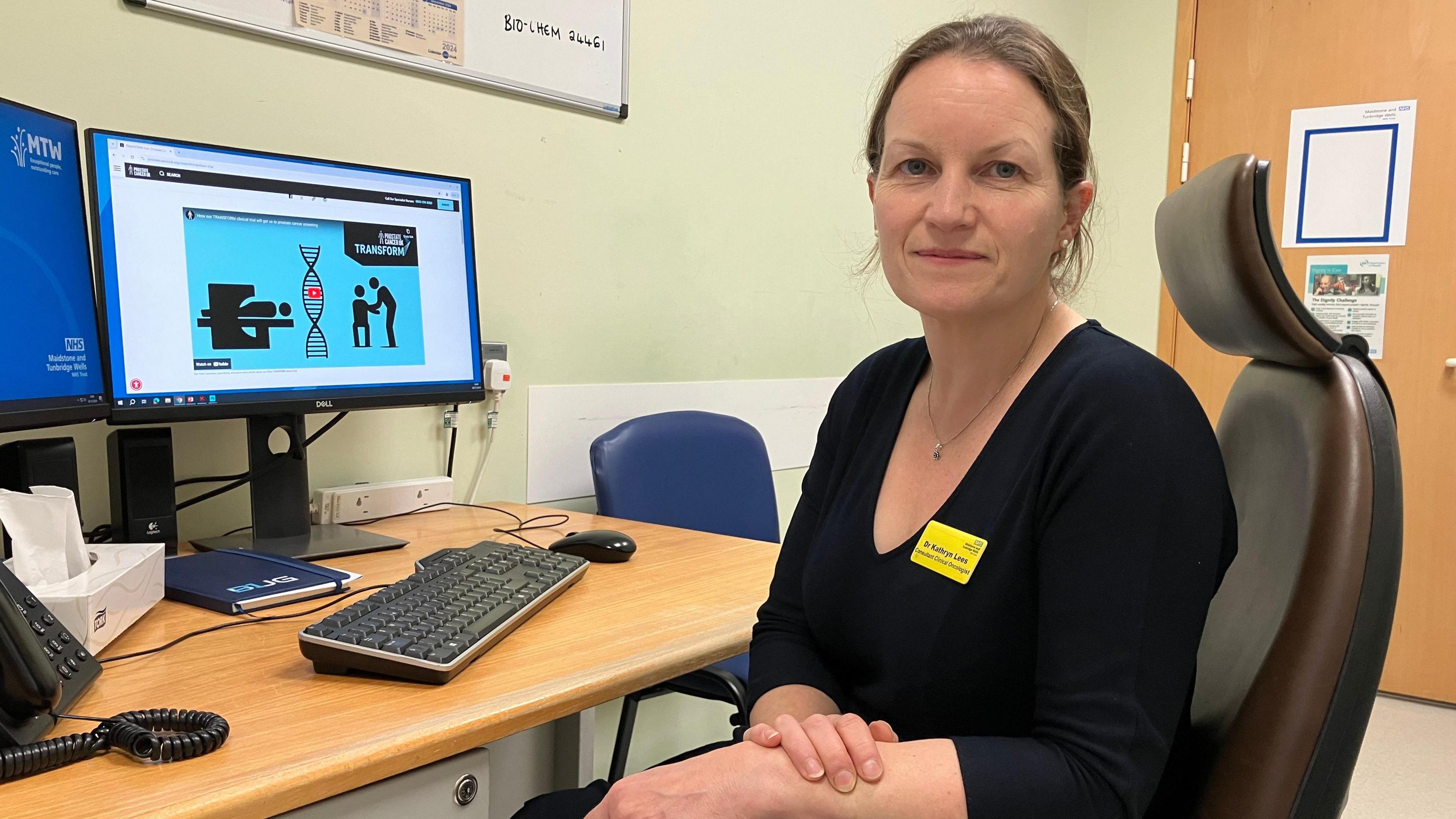 Dr Kathryn Lees. Consultant Clinical Oncologist, sitting at her desk in Maidstone Hospital .