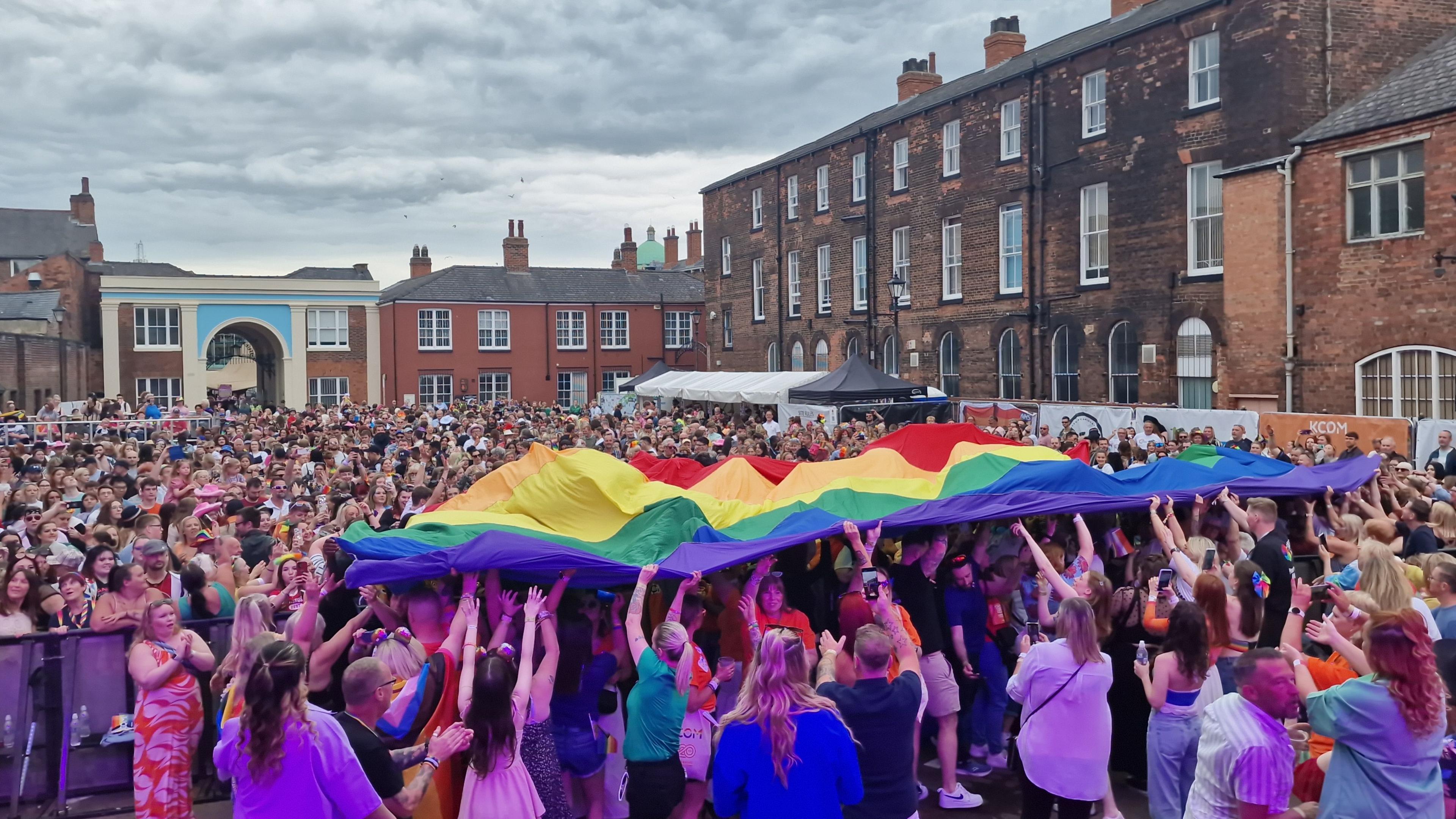 crowds surf a pride flag