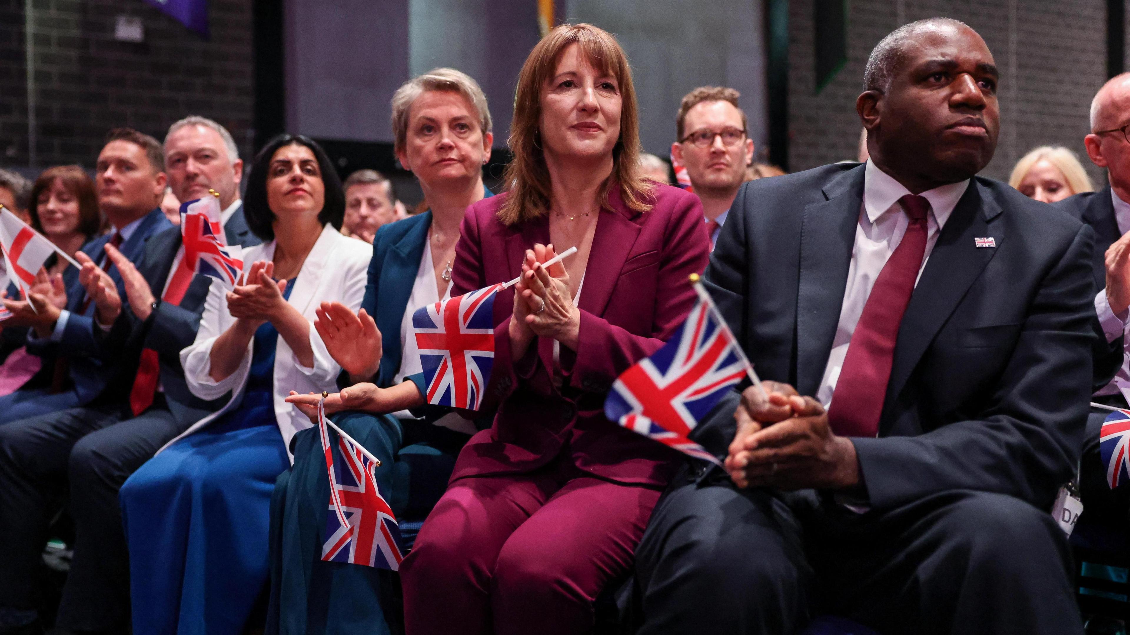 Labour ministers Shabana Mahmood, Yvette Cooper, Rachel Reeves and David Lammy clutch union jacks as they sit and watch Keir Starmer's conference speech