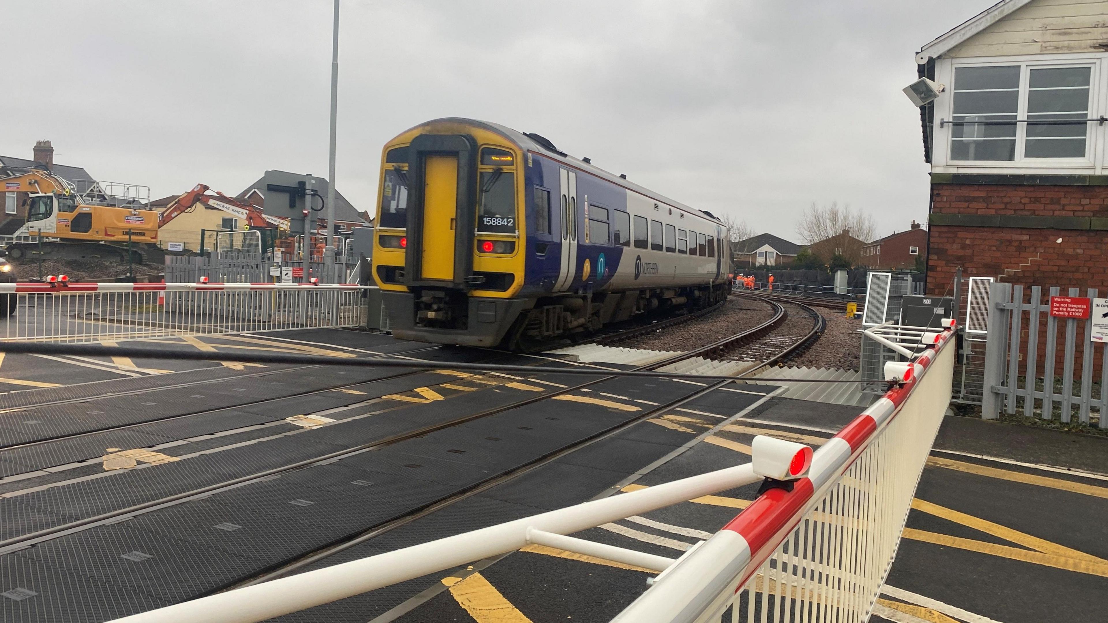 A Northern train passes the first of two level crossings at Bedlington station 