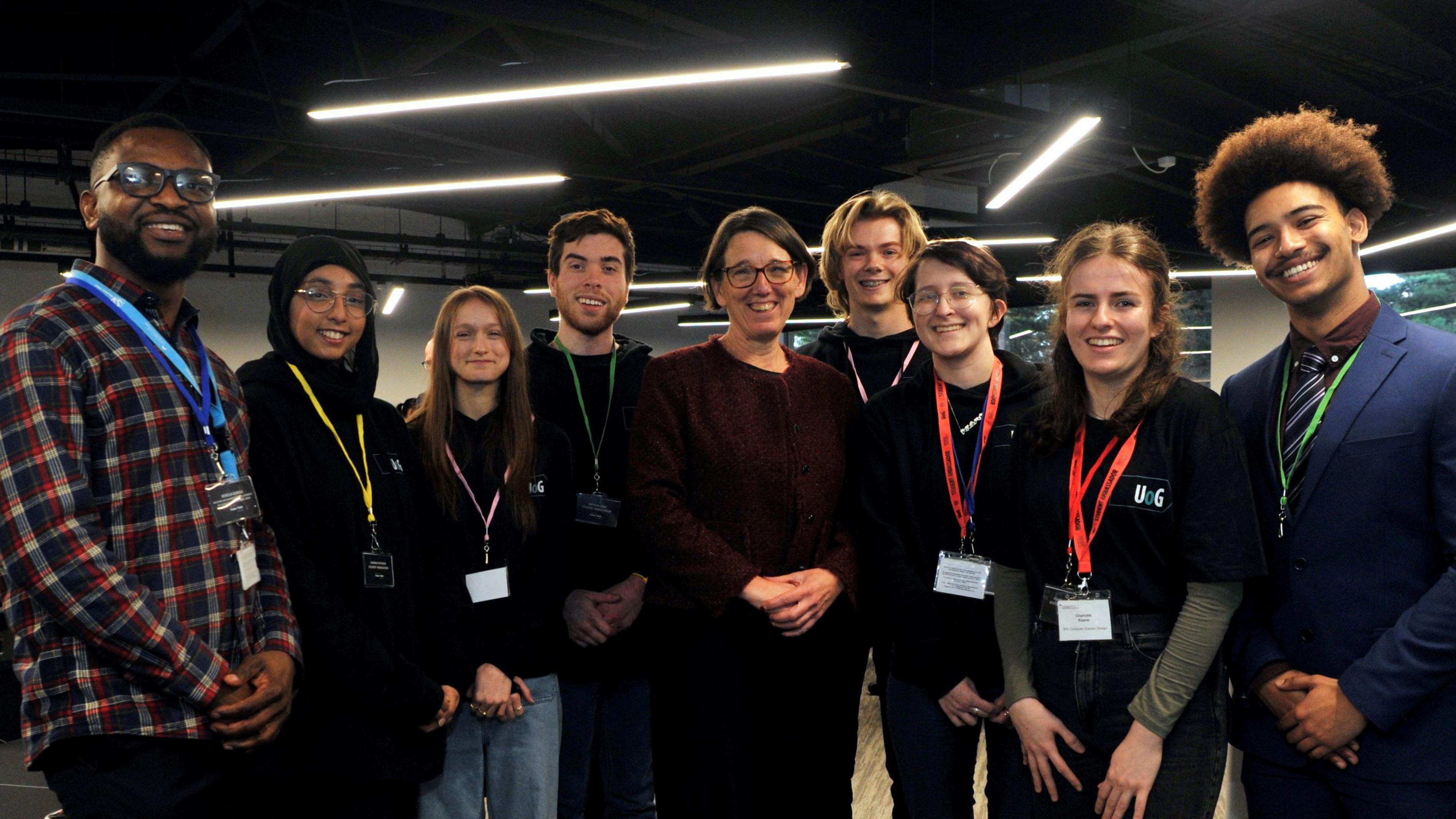 Anne Keast-Butler smiling with 8 students from the University of Gloucestershire.