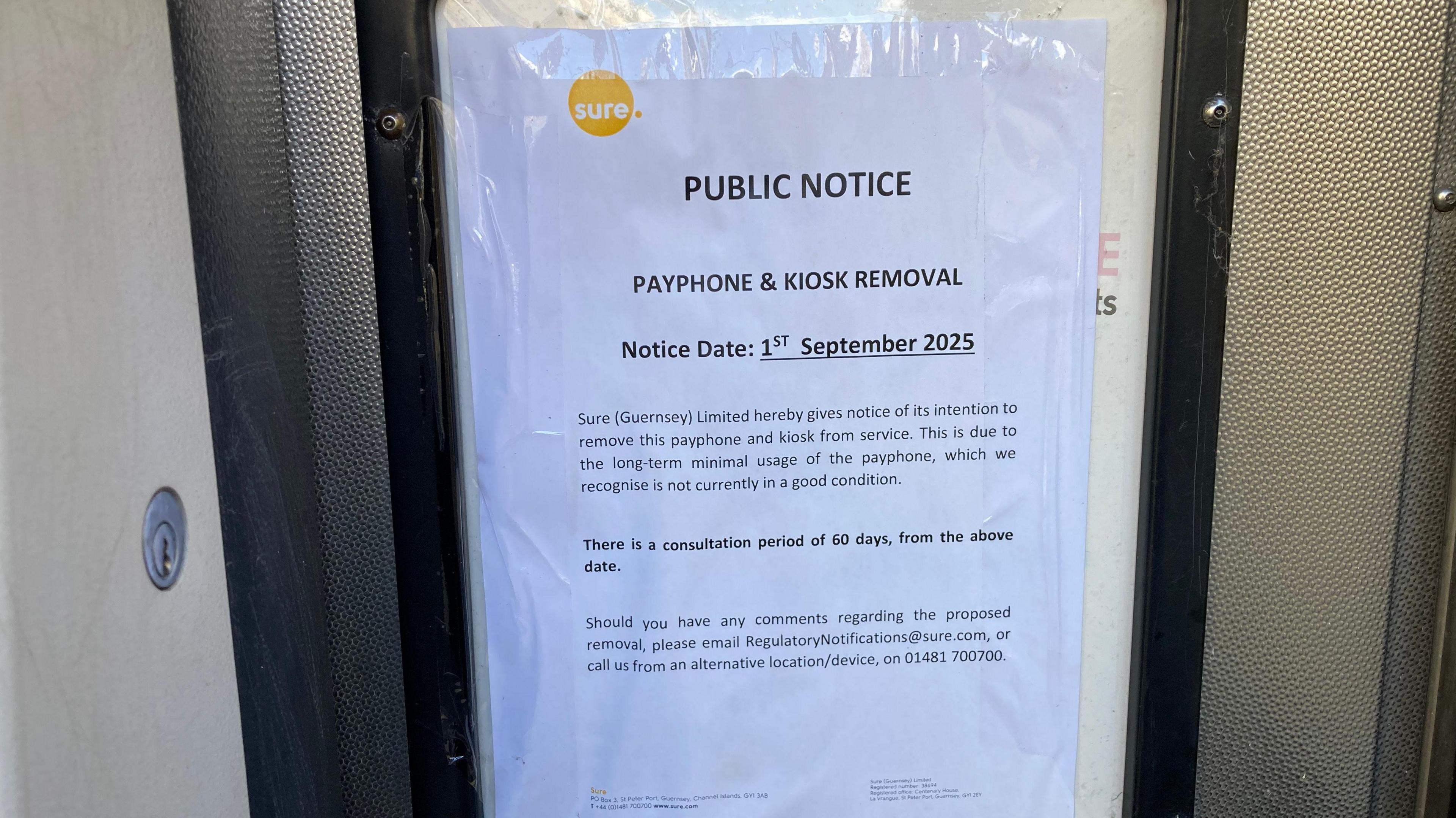 A public notice displayed in a telephone box. It says Sure (Guernsey) Limited hereby gives notice of its intention remove this payphone and kiosk from service. This is due to the long-term minimal usage of the payphone, which we recognise is not currently in a good condition. There is a consultation period of 60 days, from the above date. Should you have any comments regarding the proposed removal, please email regulatorynotifications@sure.com, or call us from an alternative location/device on 01481 700700.