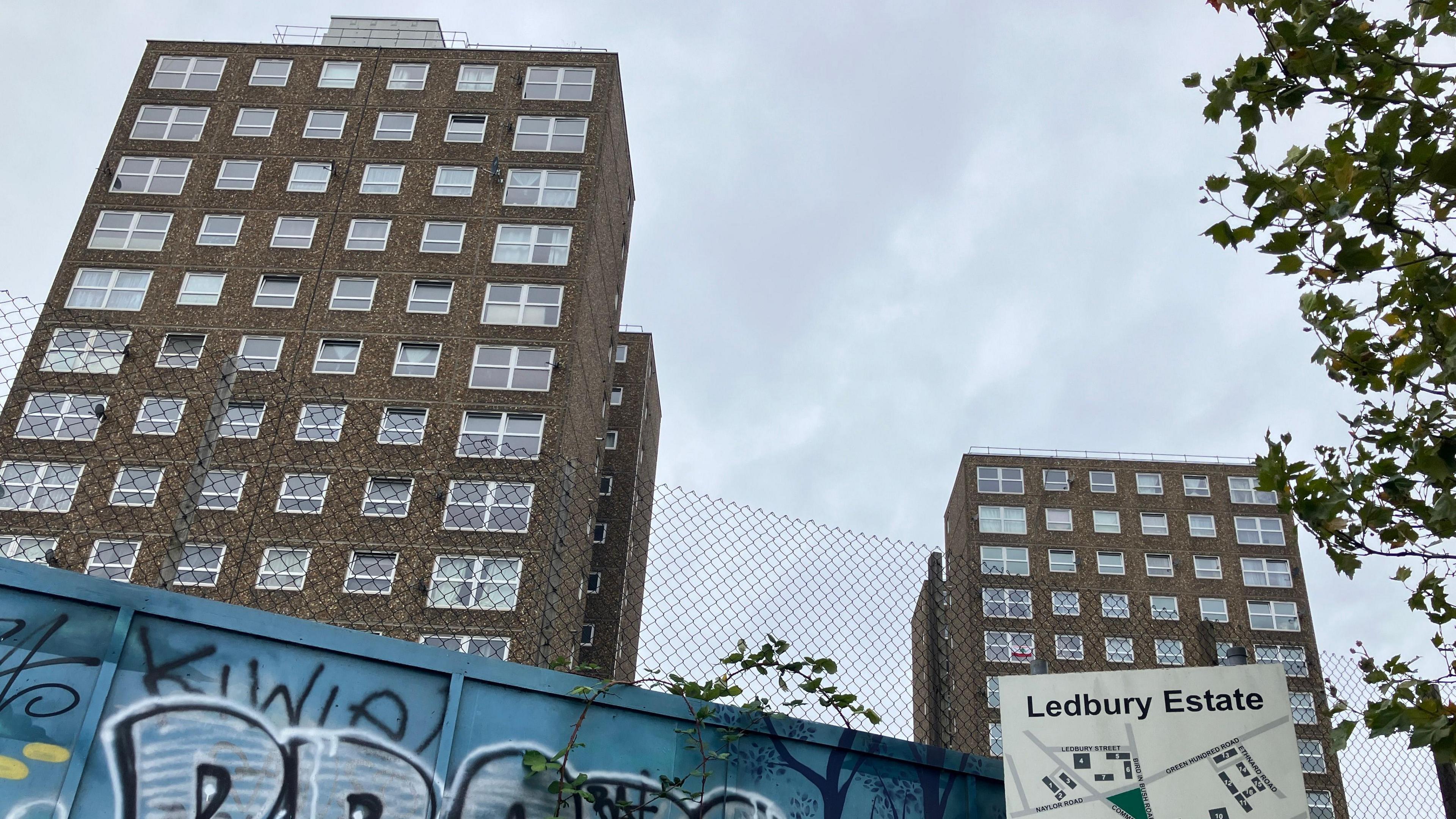 LPS blocks on the Ledbury Estate in Peckham, behind a wire mesh fence and a graffitied panel