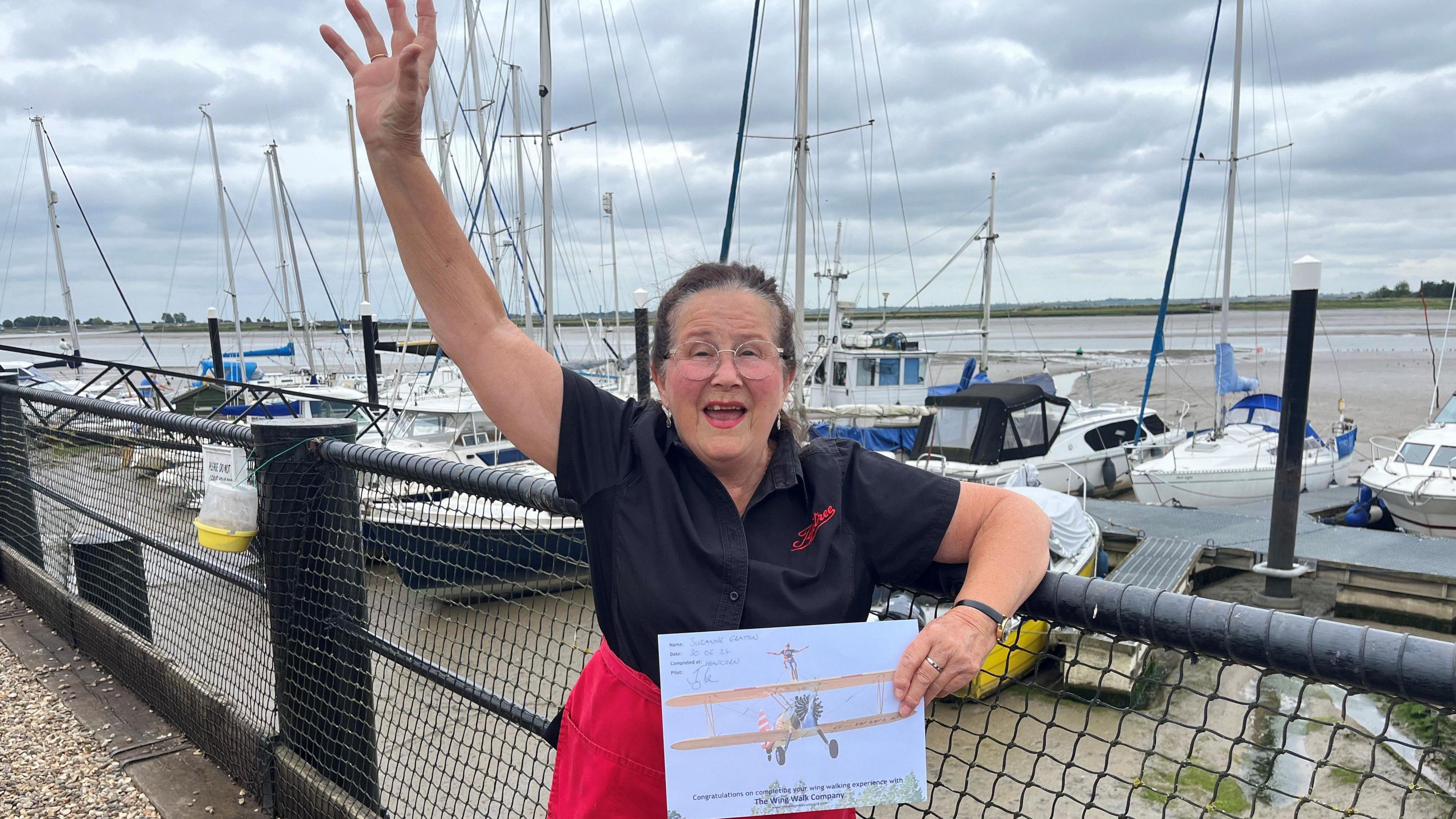 Suzanne Gratton smiling at the camera while holding a certificate