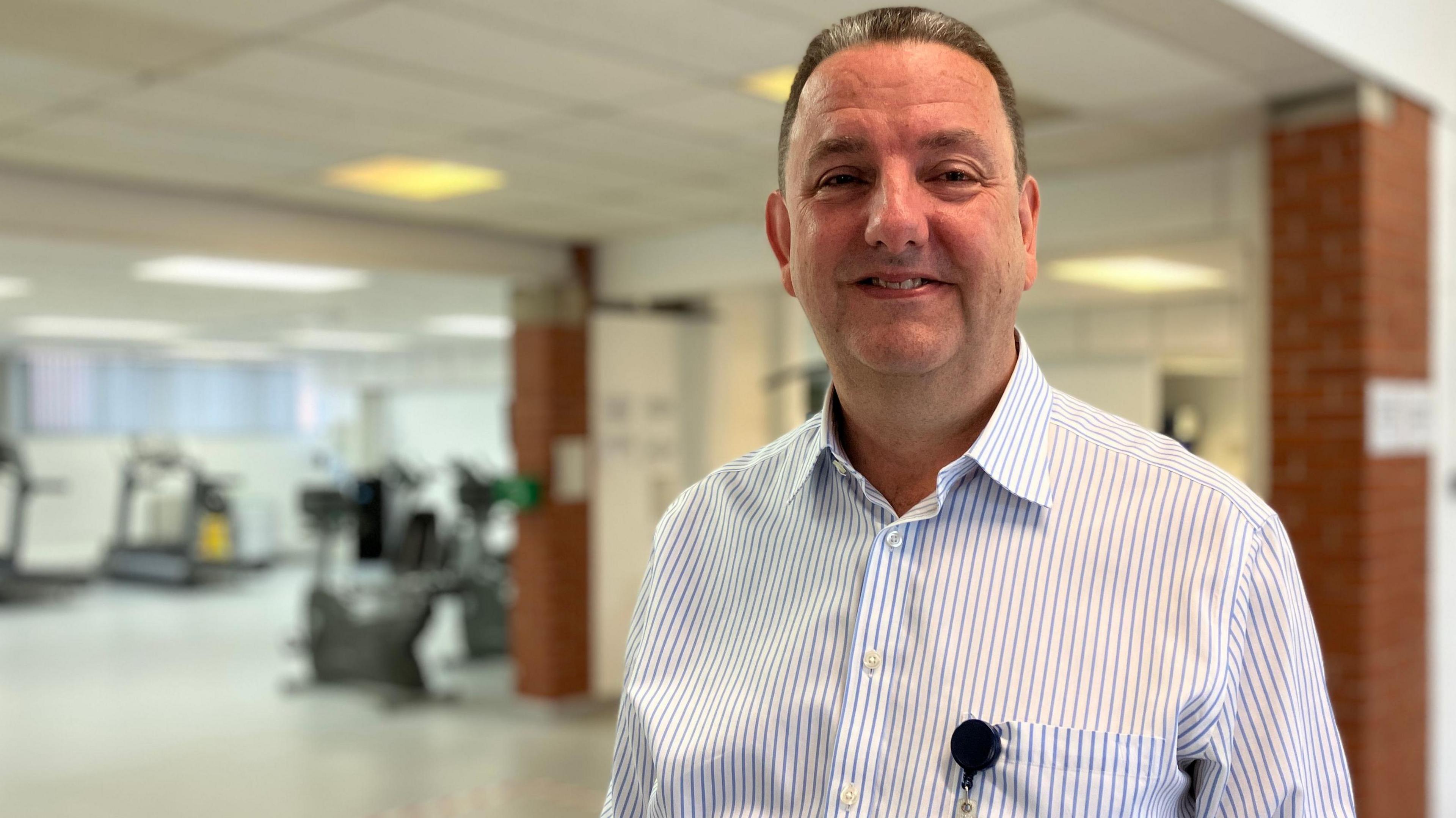 Dr Neil Agnew in a gym smiling at the camera