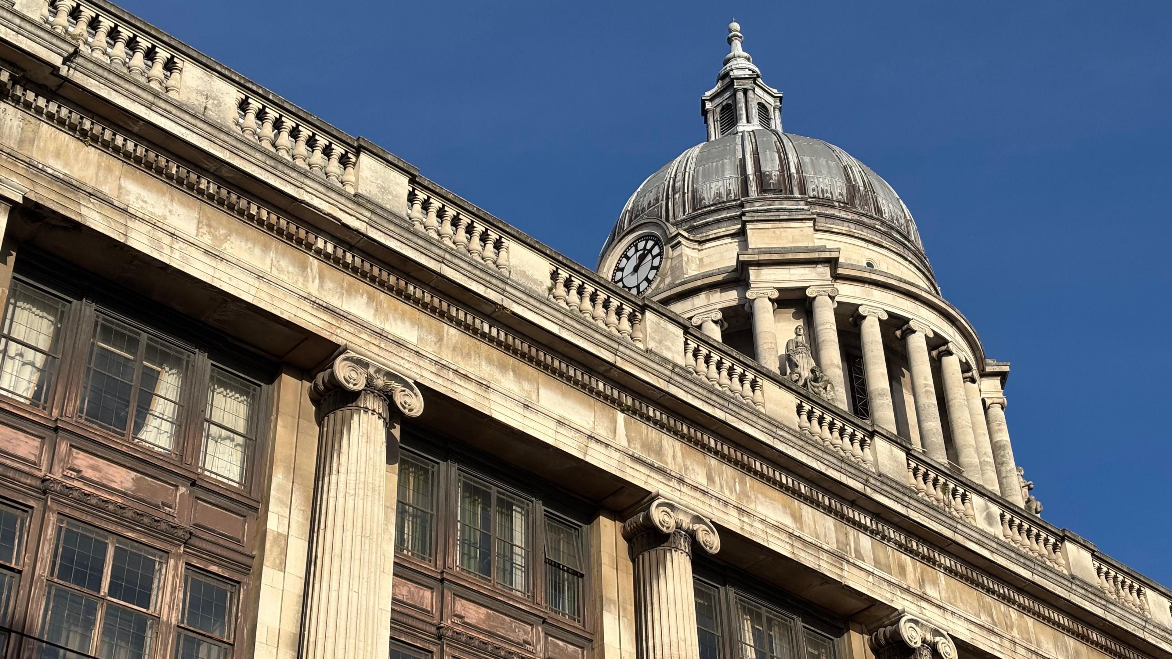 Nottingham Council House is pictured with its dome. There is a clear blue sky in the background