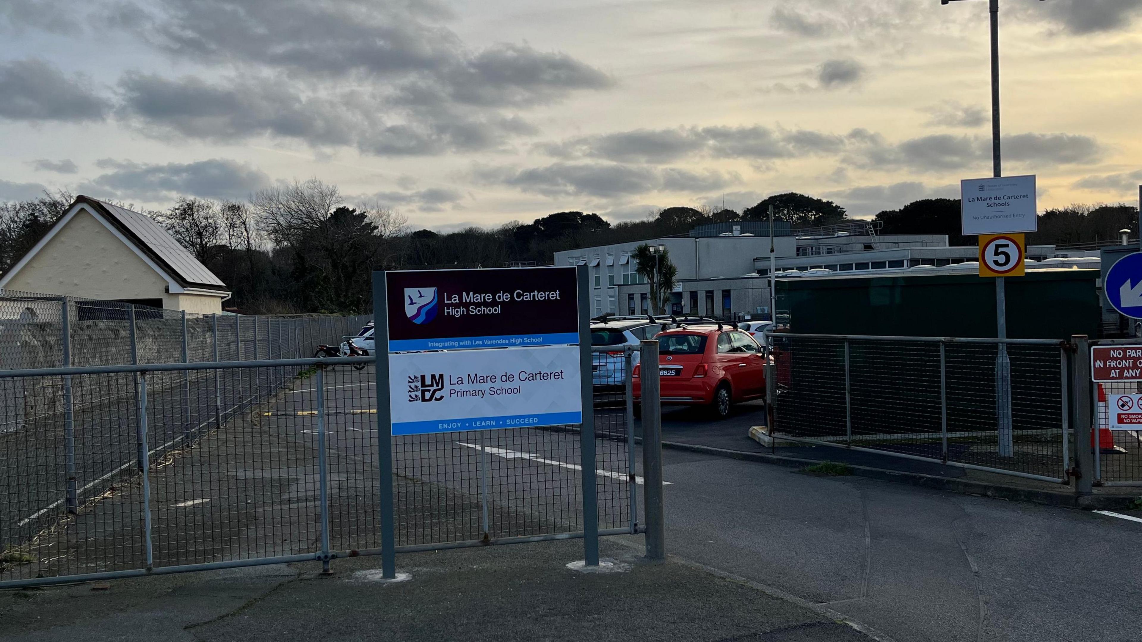 A picture of the sign outside La Mare De Carteret High School at twilight.