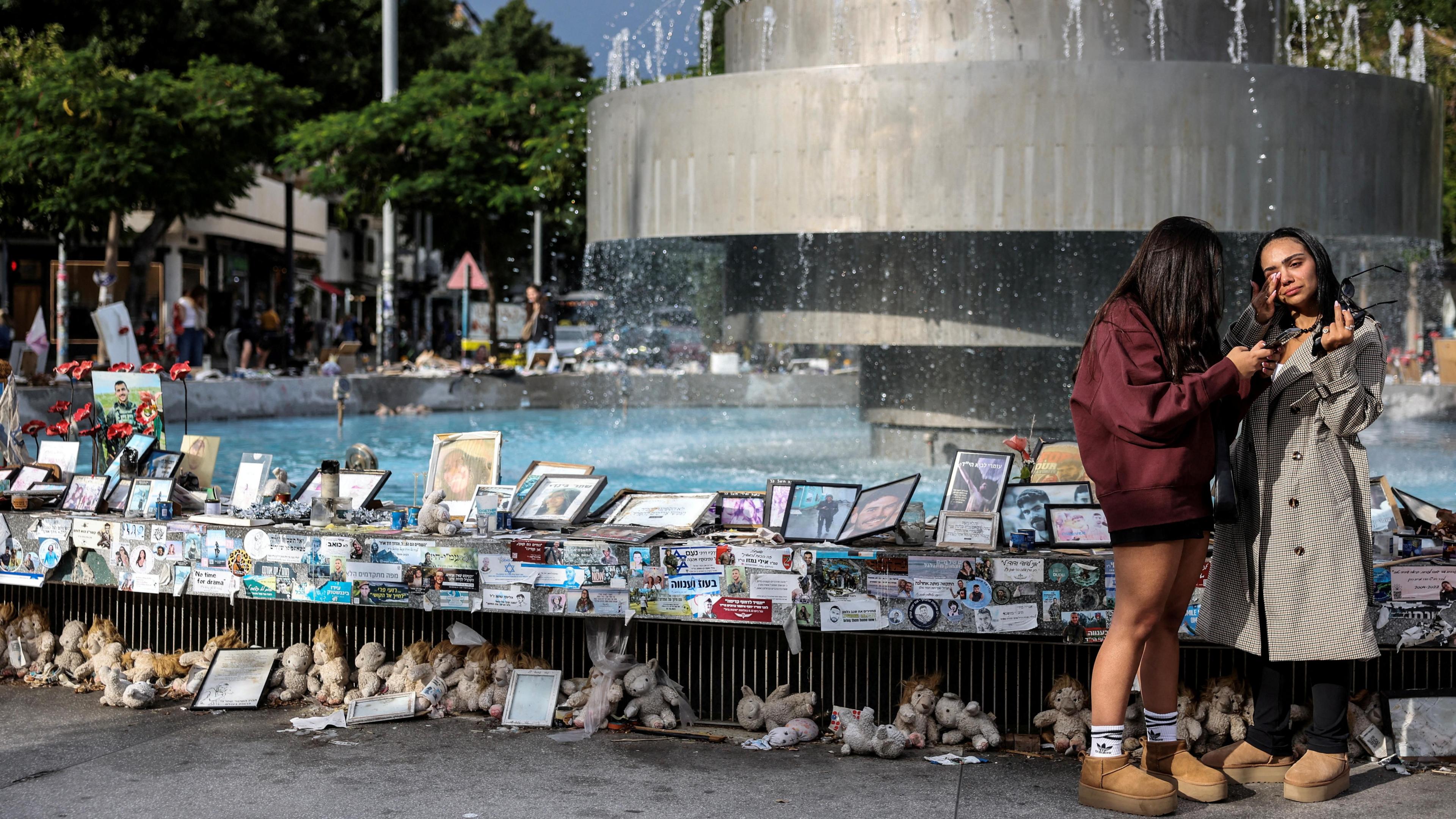 Two Israeli women stand beside photos and memorabilia of people taken back to Gaza as hostage during Hamas’s 7 October 2023 attack, at Dizengoff Square, Tel Aviv, Israel (20 November 2024)