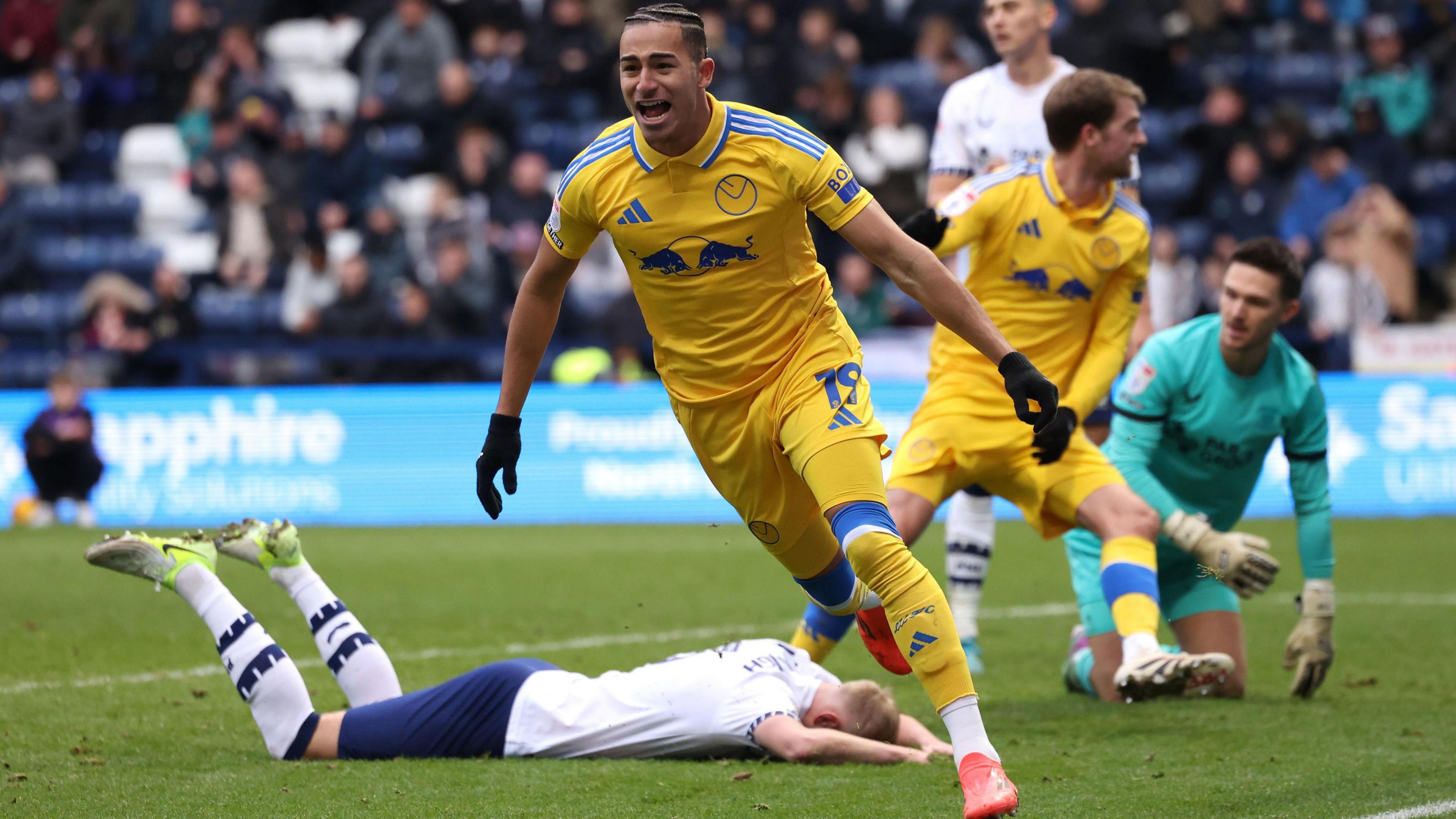 Leeds forward Mateo Joseph celebrates with Preston defender Jack Whatmough lying on the floor after his late own goal