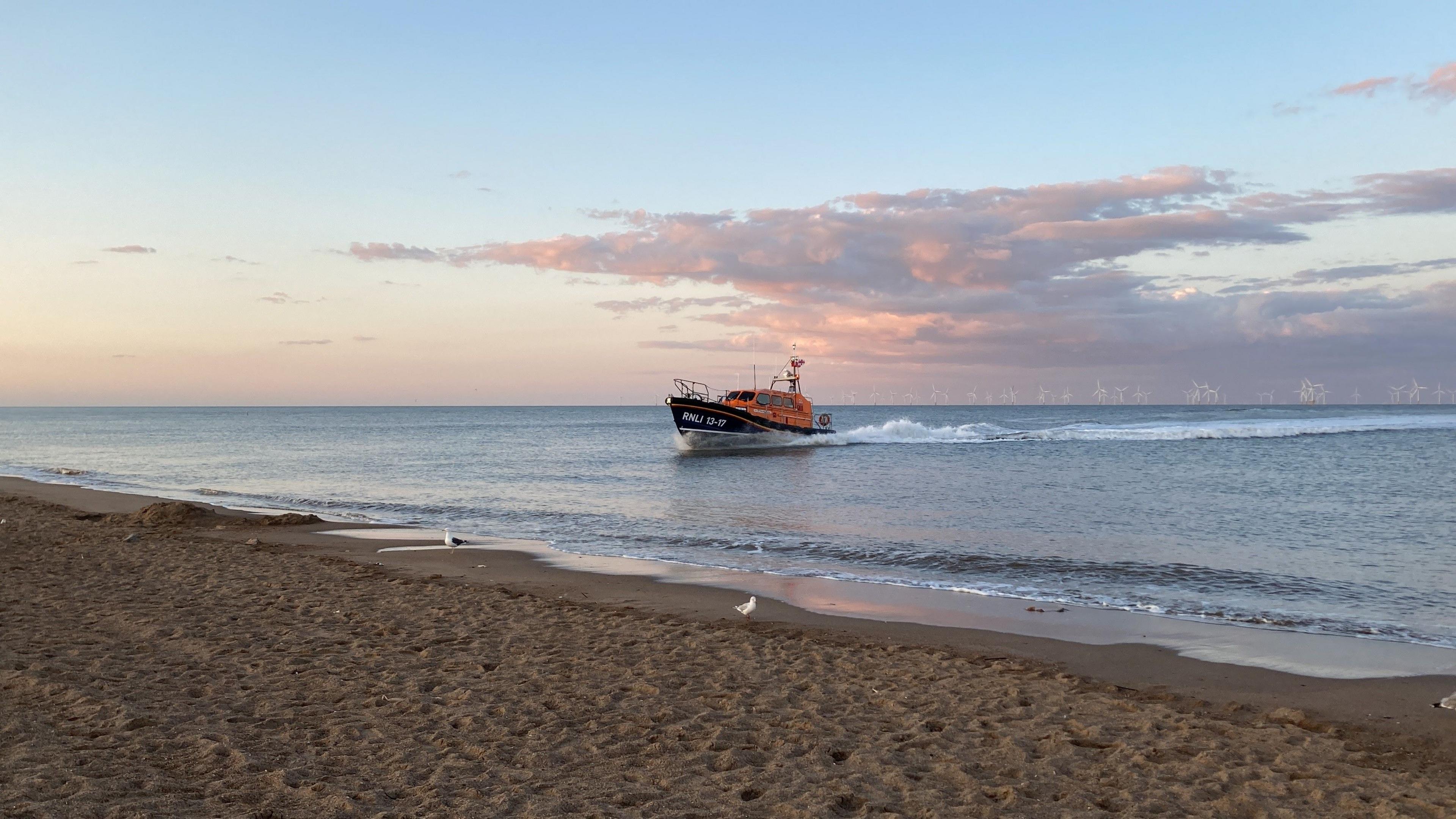 Skegness RNLI's Shannon class all-weather lifeboat - the Joel and April Grunnill - is pictured coming ashore at Skegness beach on an early summer's evening.