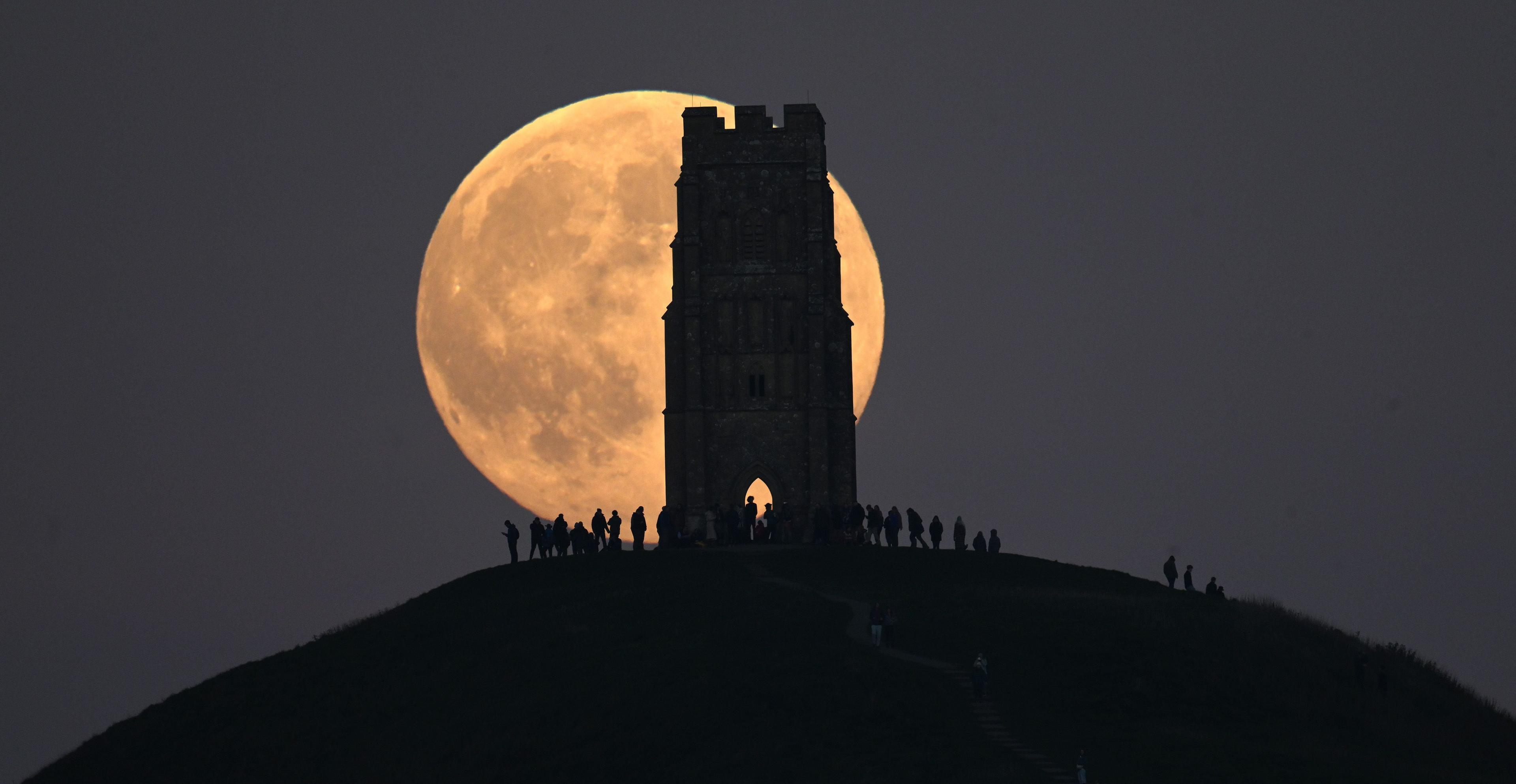 A huge supermoon can be seen behind Glastonbury Tor, a Grade I listed building in Somerset.